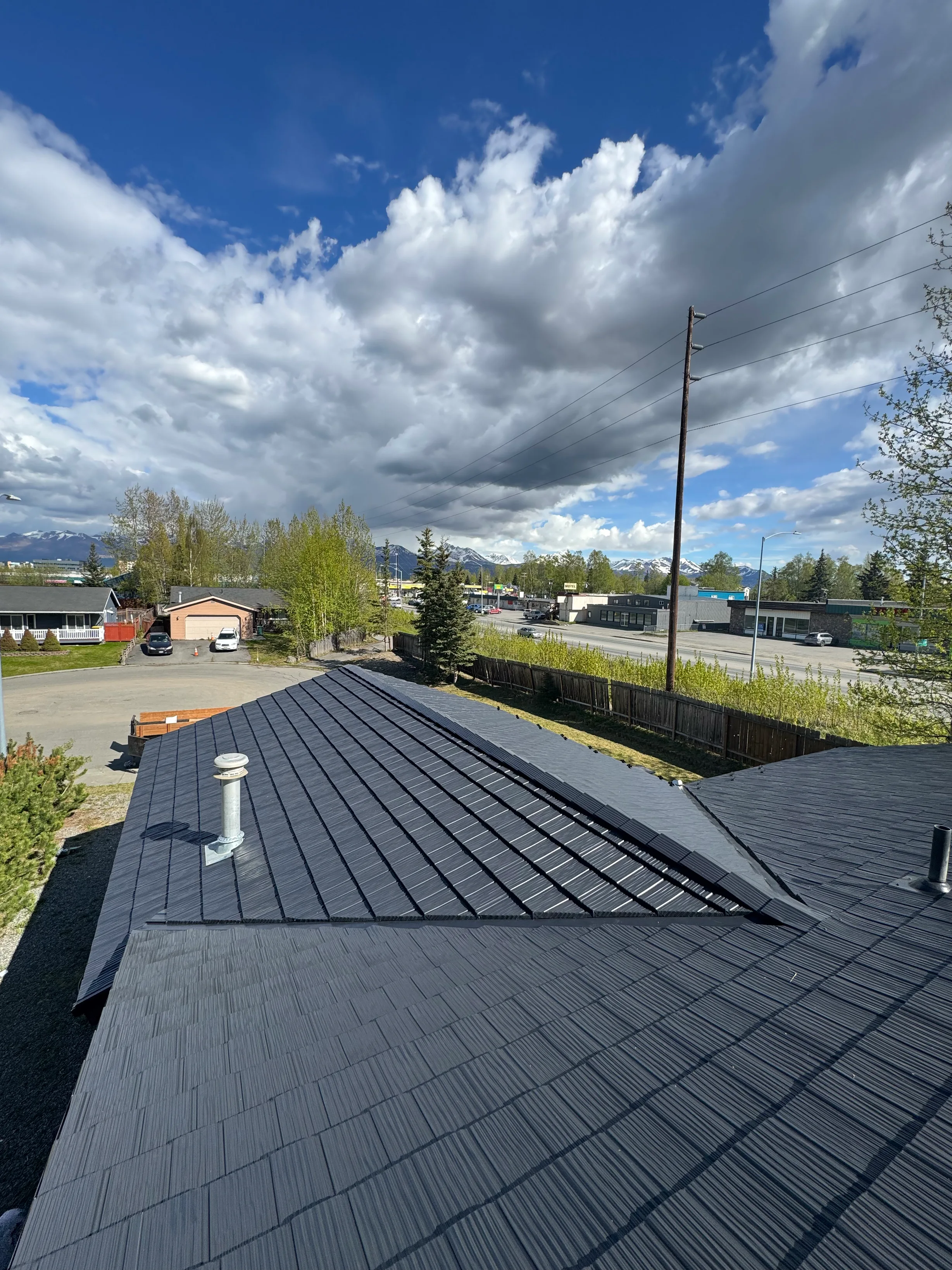 A modern metal roof on a single-family home in a rural setting
