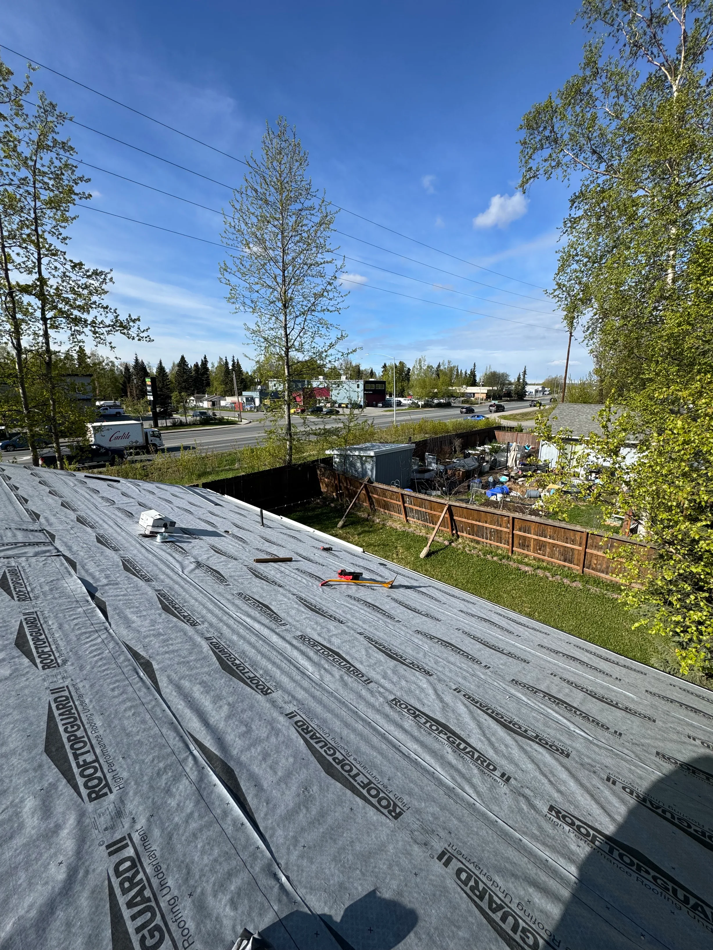 A metal roof under construction with gray underlayment visible.