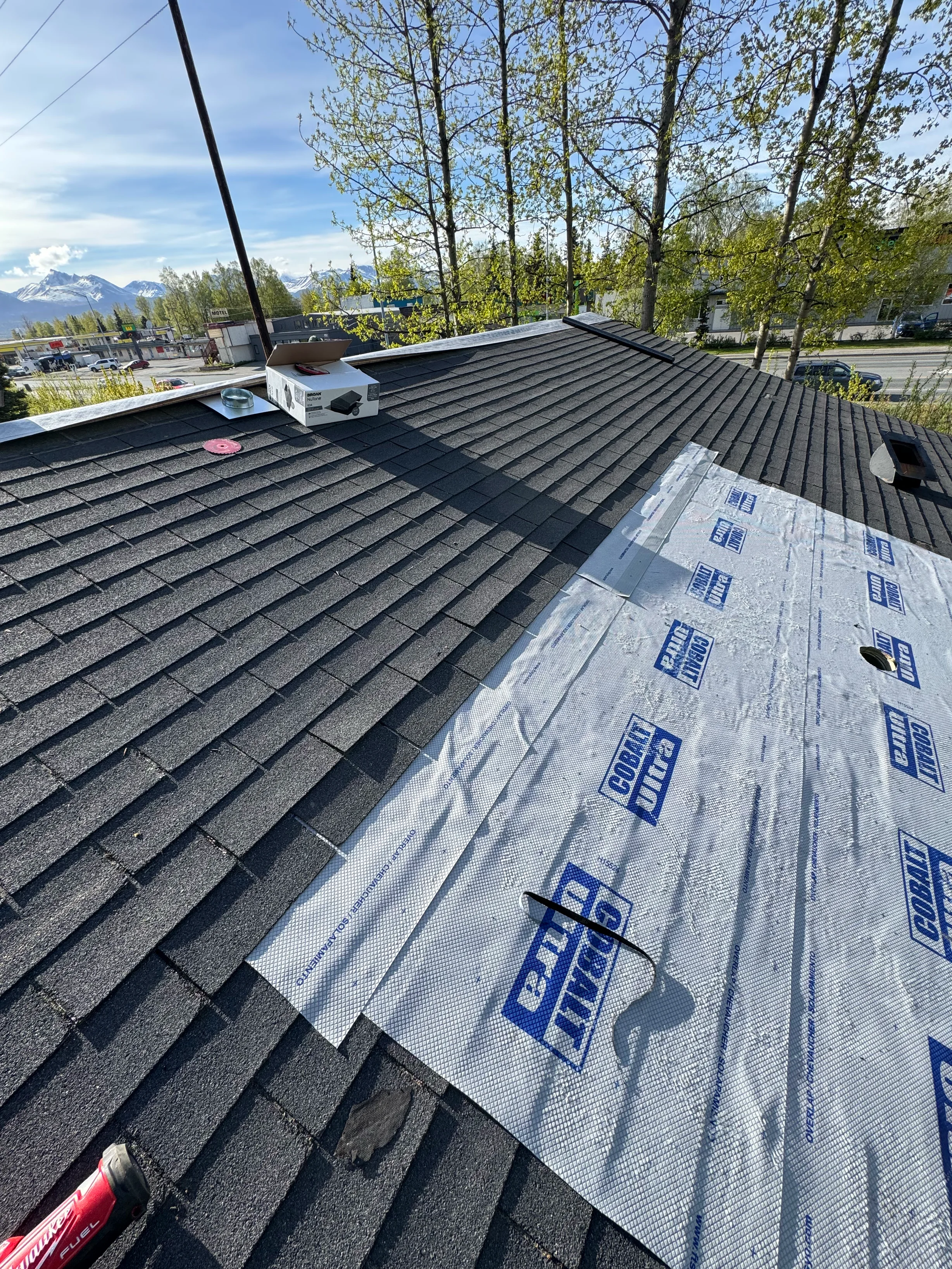 Black Interlock Shake aluminum roof being installed on the home, replacing a rotten asphalt shingle roof, Anchorage, Alaska
