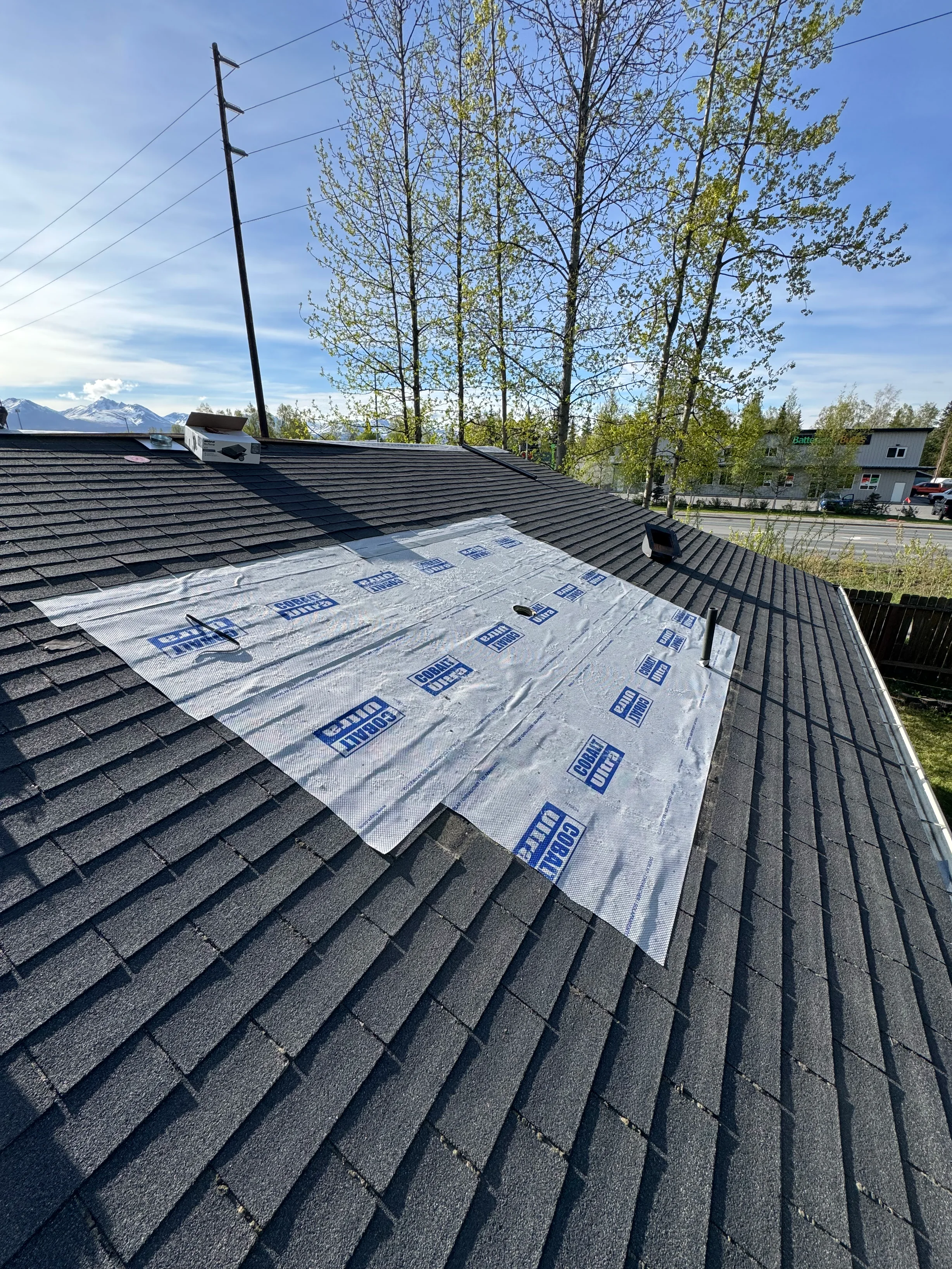 Black Interlock Shake aluminum roof being installed on the home, replacing a rotten asphalt shingle roof, Anchorage, Alaska