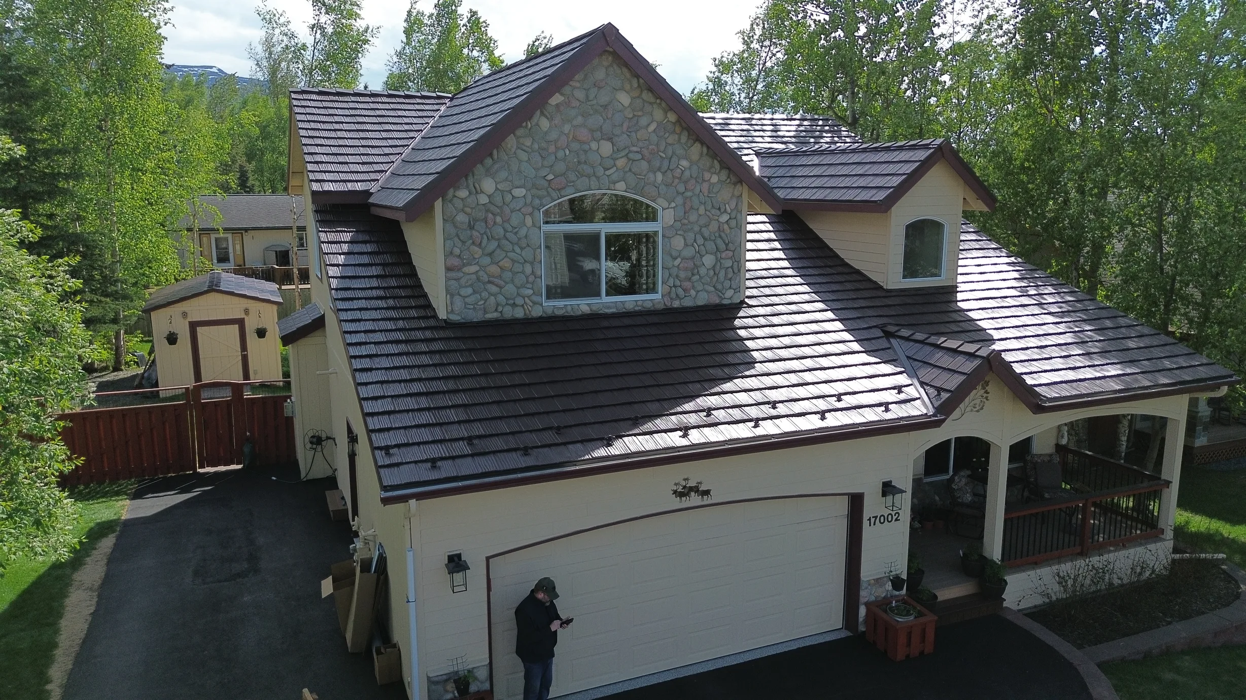 Metal roof with brown panels on a cream-colored Craftsman-style home