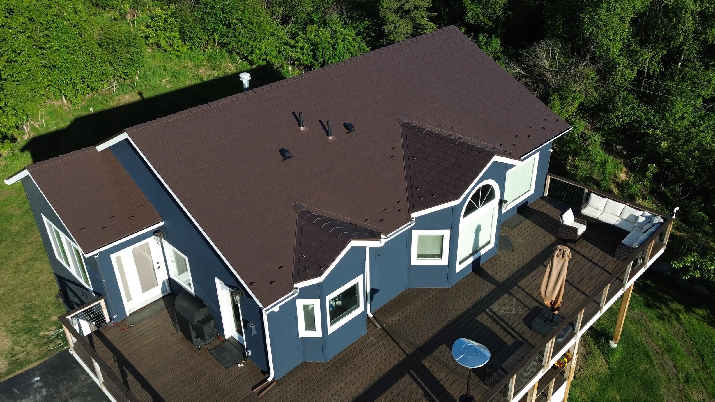 A modern house with a brown metal roof and white trim