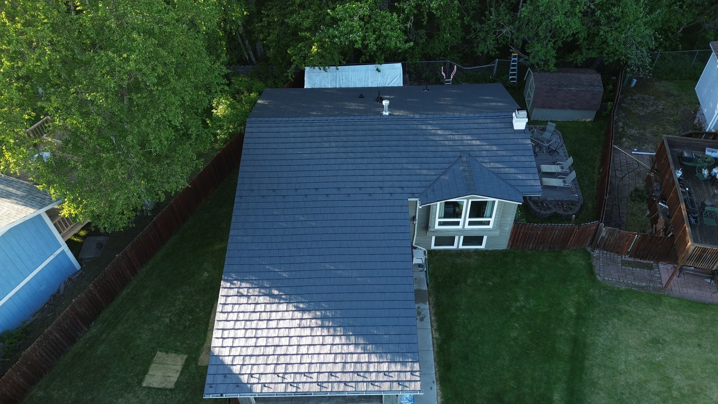 A metal roof on a craftsman style single-family home in a suburban setting.
