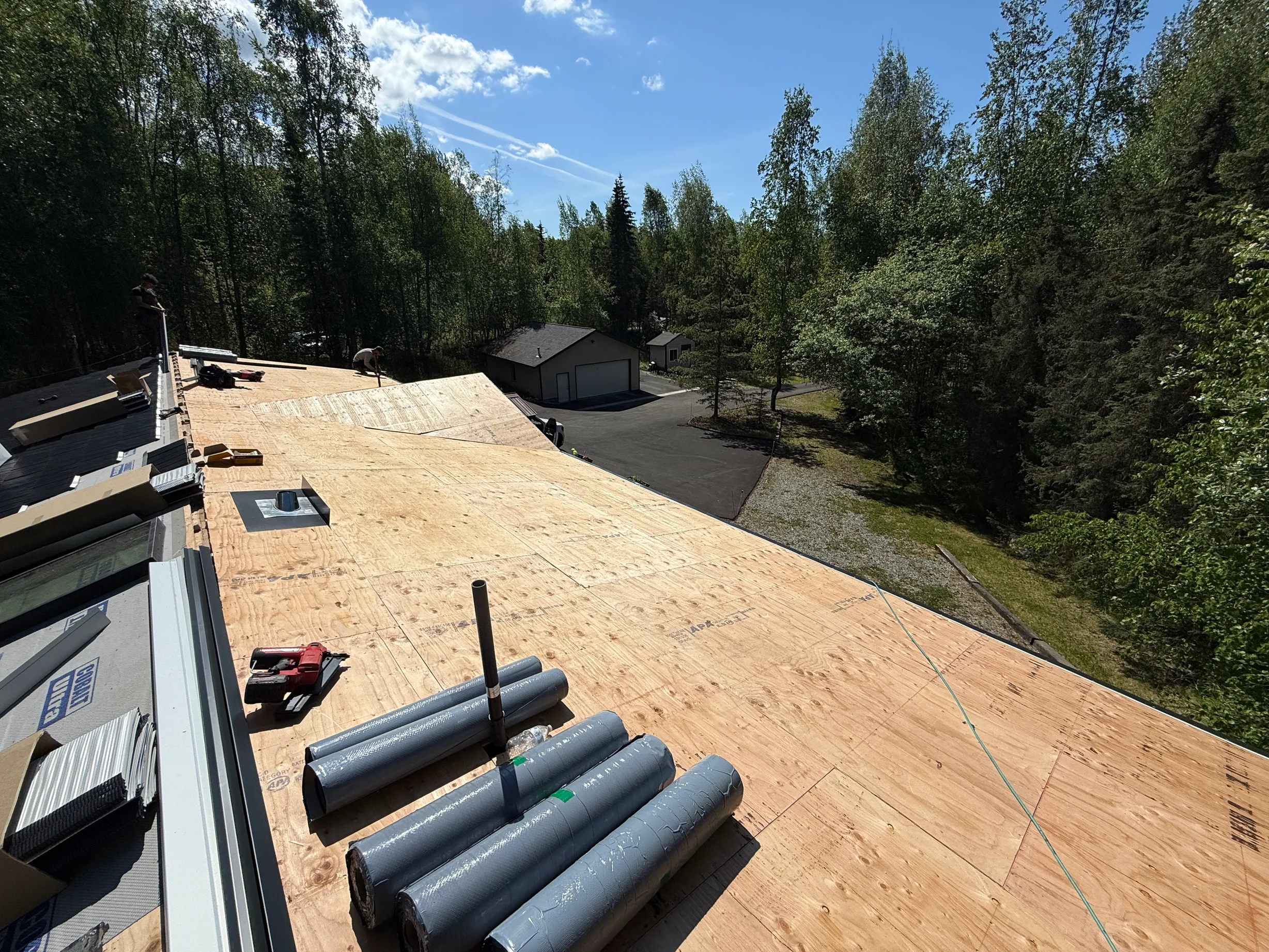 A metal roof under construction with a large section already covered in underlayment.