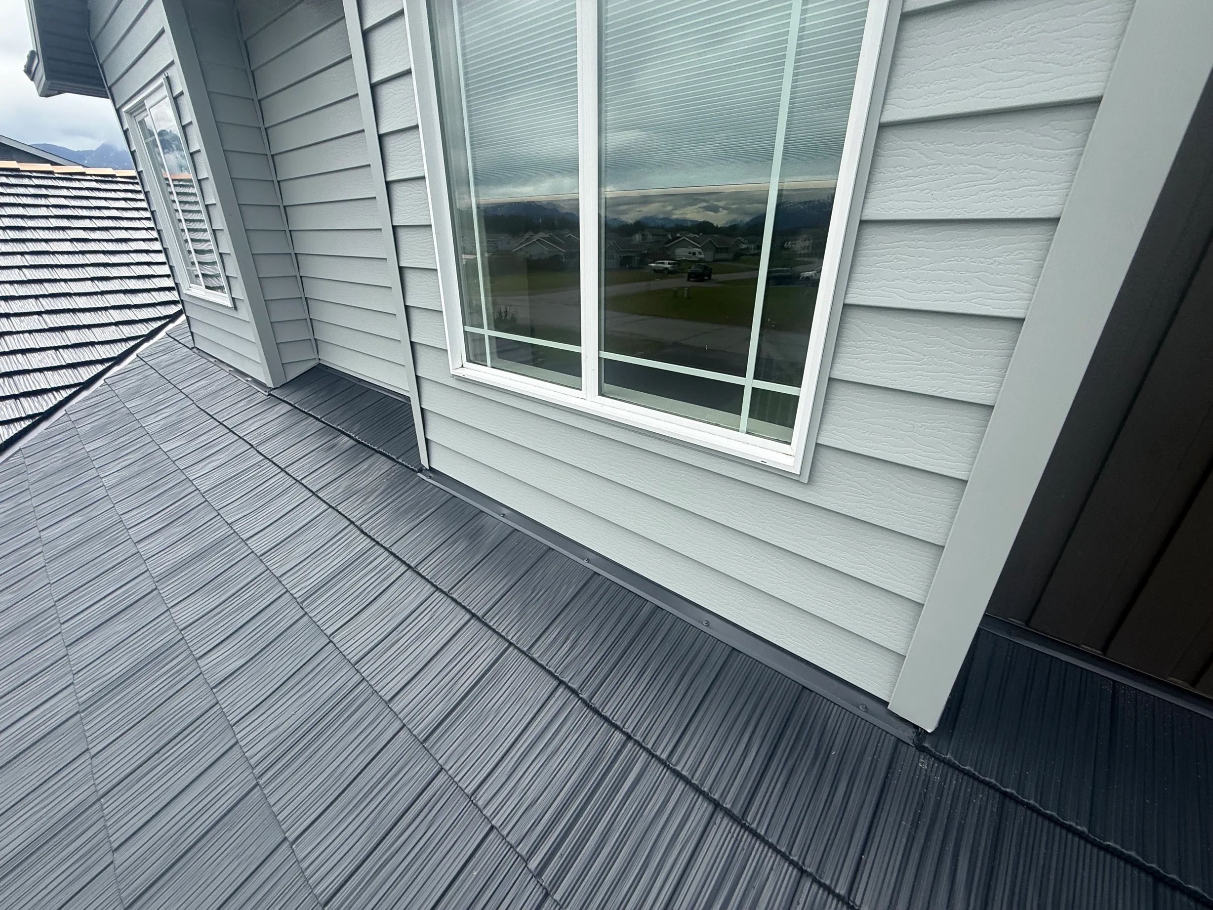 A modern metal roof on a single-family home in an urban setting.
