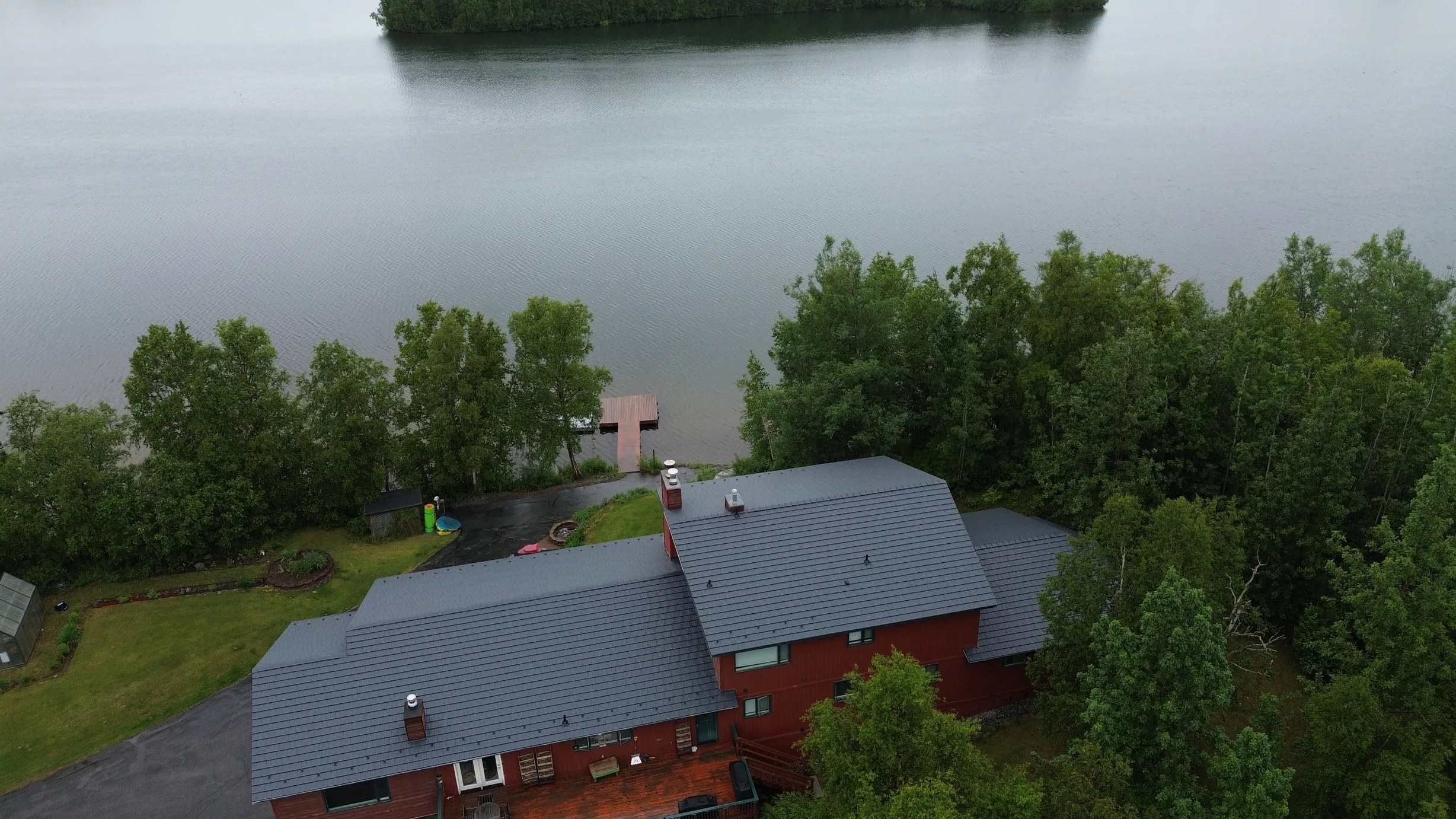 Aerial view of a red brick house with a grey metal roof