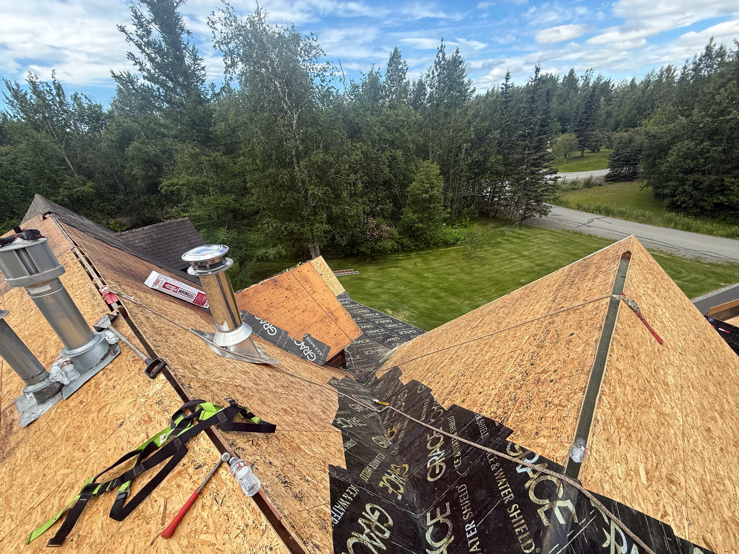 A house with a metal roof under construction in a forested area