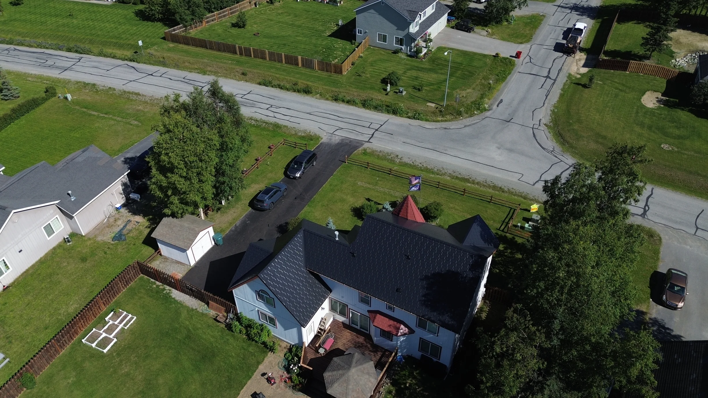 A white colonial home with a black metal roof