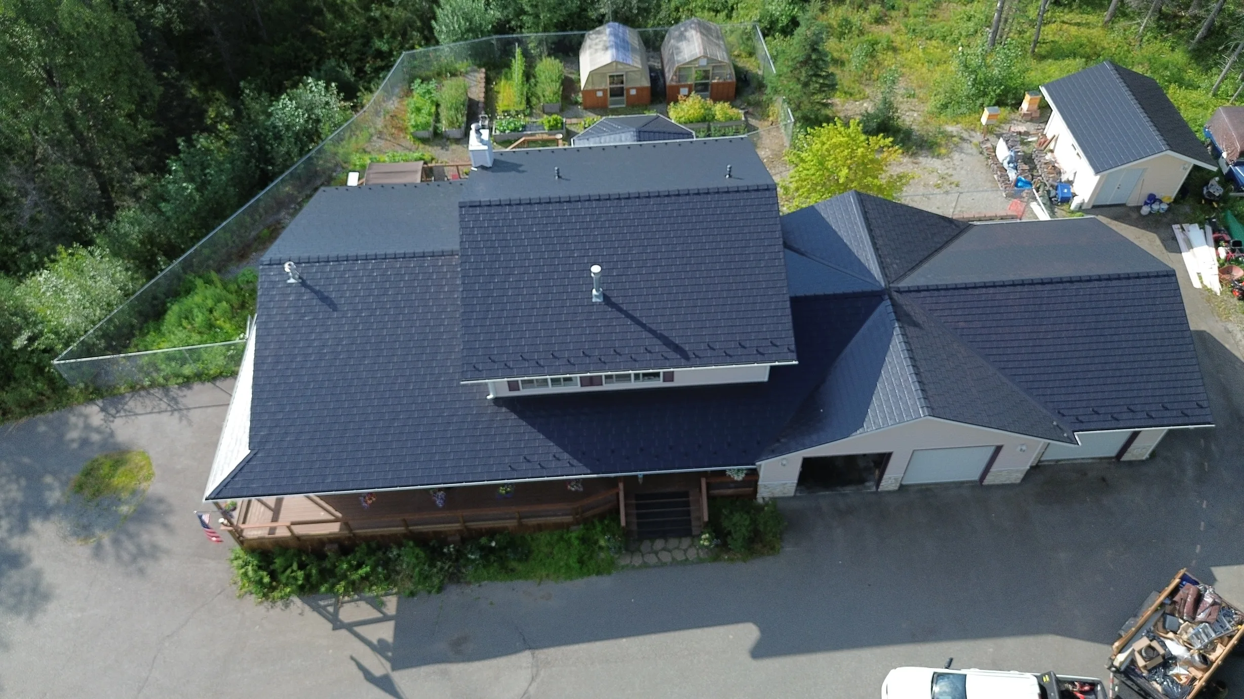 Aerial view of a modern single-family home with a black metal roof