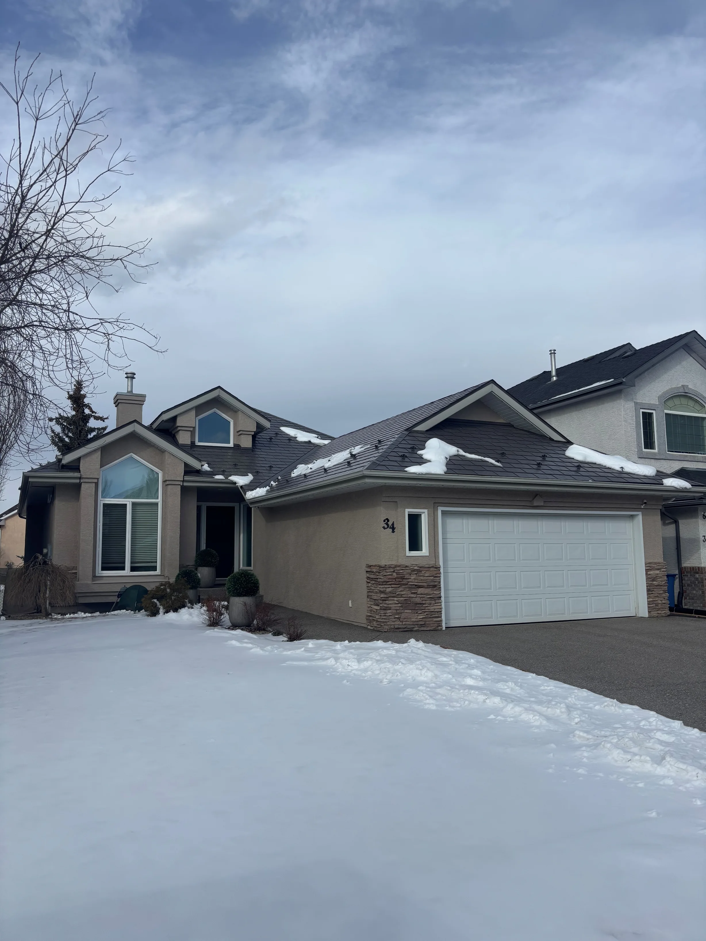 Weathered Interlock Slate aluminum roof on a beige one-storey home with a garage in a suburban, Calgary, Alberta