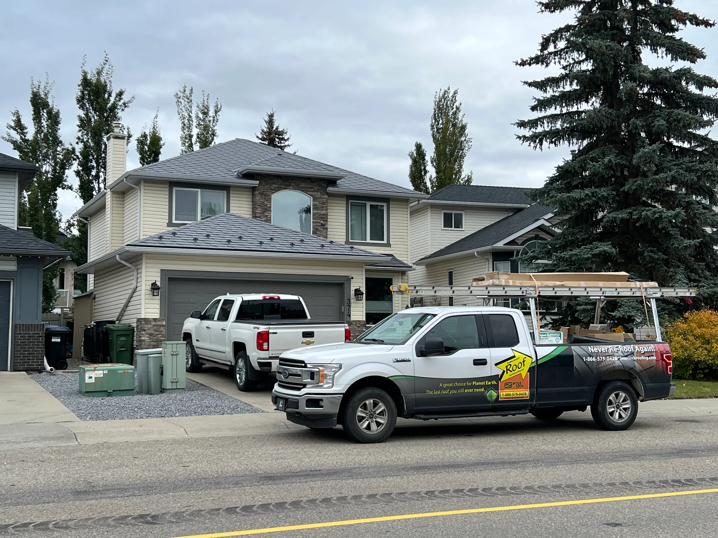 Charcoal Grey Interlock Slate aluminum roof on a white house with a metal roof in an urban setting, Calgary, Alberta
