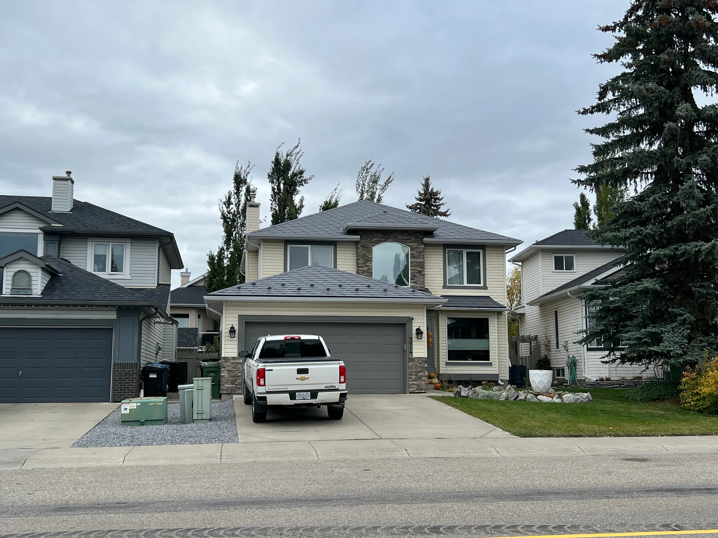 Charcoal Grey Interlock Slate aluminum roof on a two-storey home with dormers in a suburban neighbourhood, Calgary, Alberta