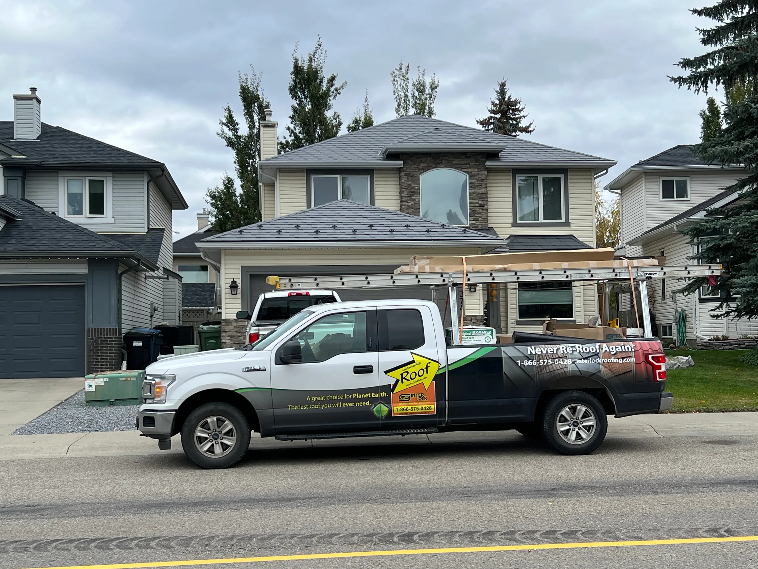 Charcoal Grey Interlock Slate aluminum roof on a beige two-storey home with a metal roof in Calgary,, Calgary, Alberta