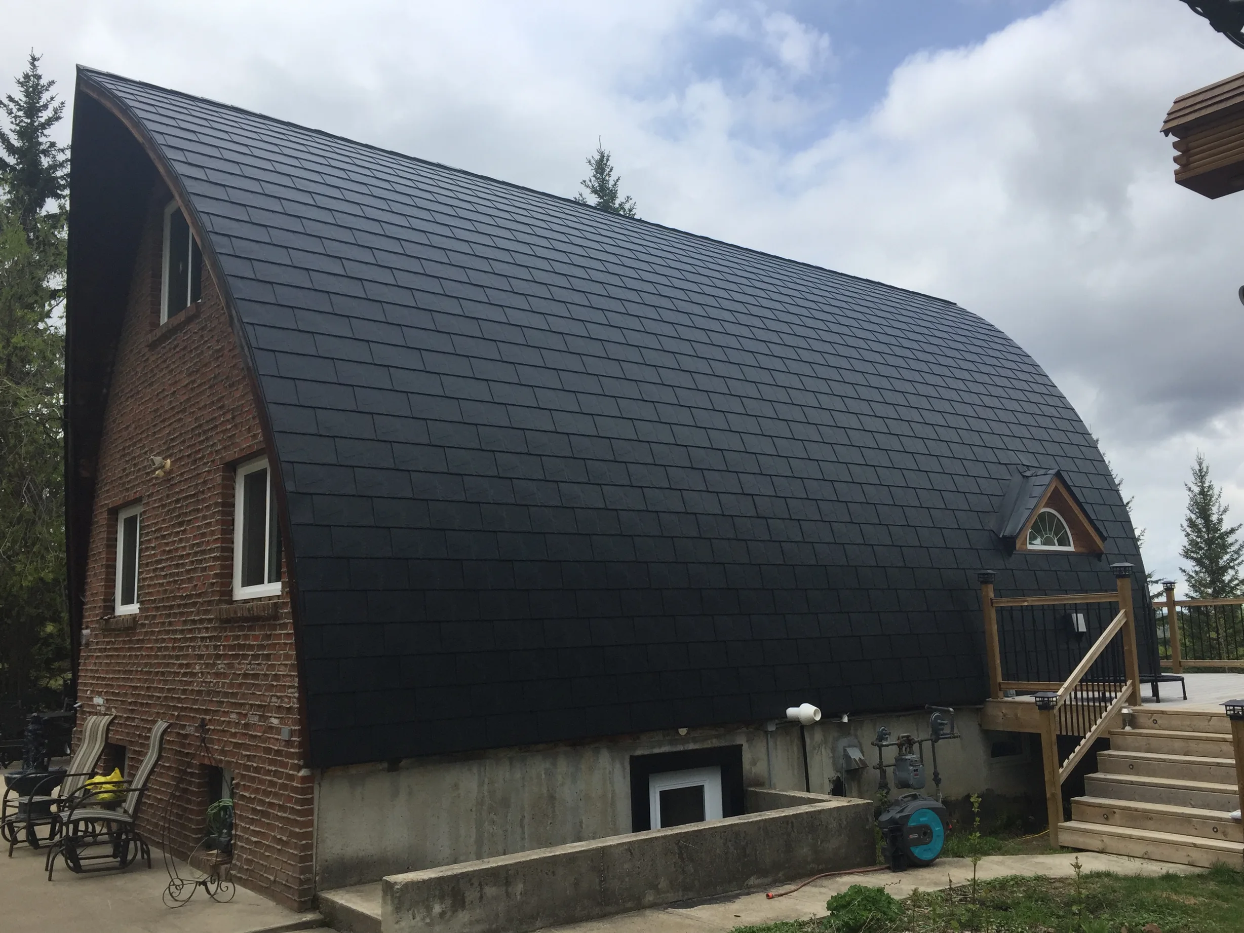 Black Interlock Slate aluminum roof on a brown chalet with a metal roof in a forested area, Whitecourt, Alberta