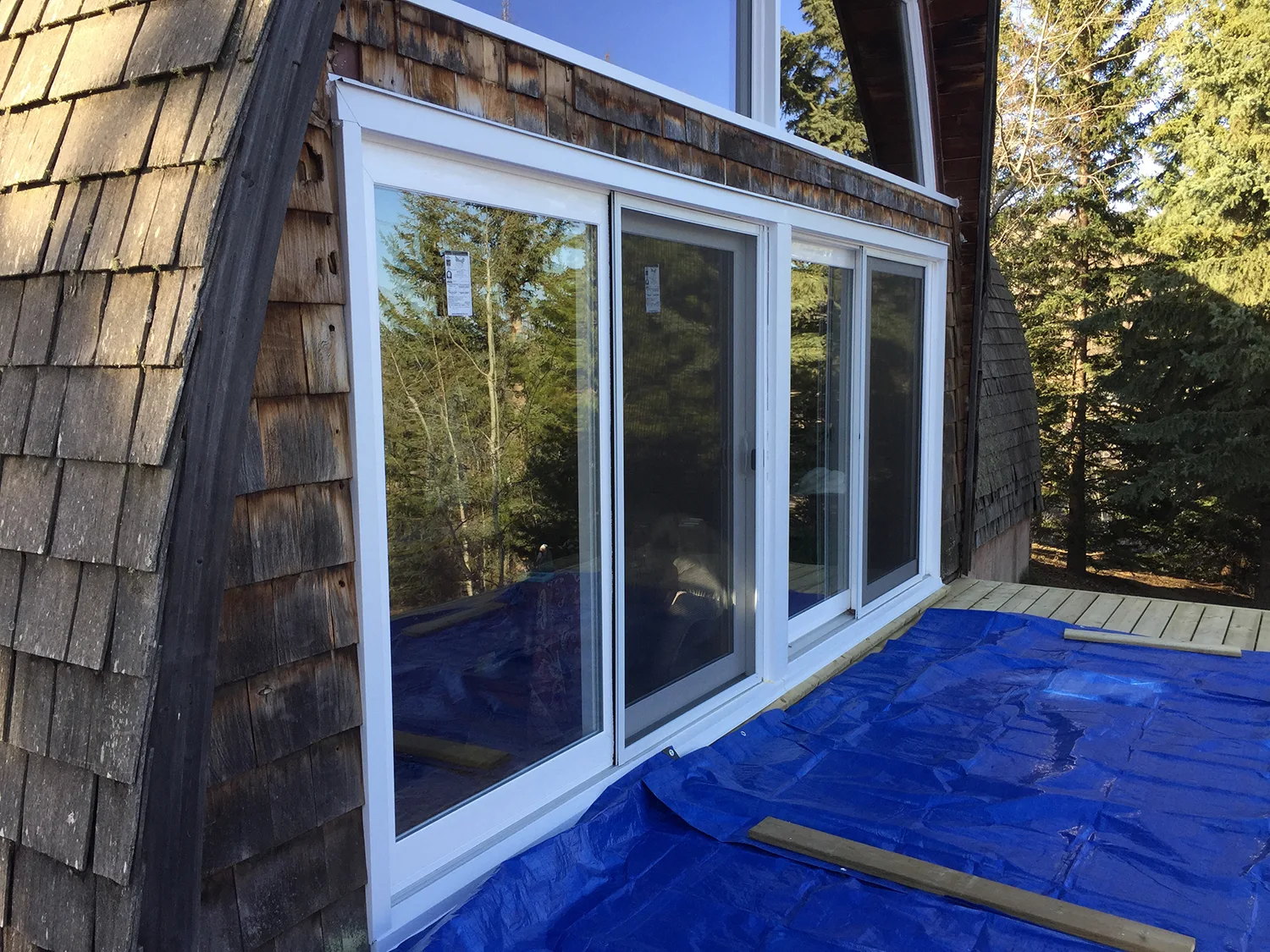 Black Interlock Slate aluminum roof on a brown A-frame house with a metal roof in a forest, Whitecourt, Alberta