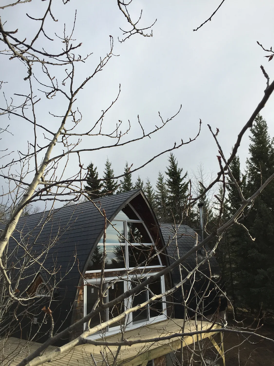 Black Interlock Slate aluminum roof on a black metal roof on a chalet style house in the forest, Whitecourt, Alberta