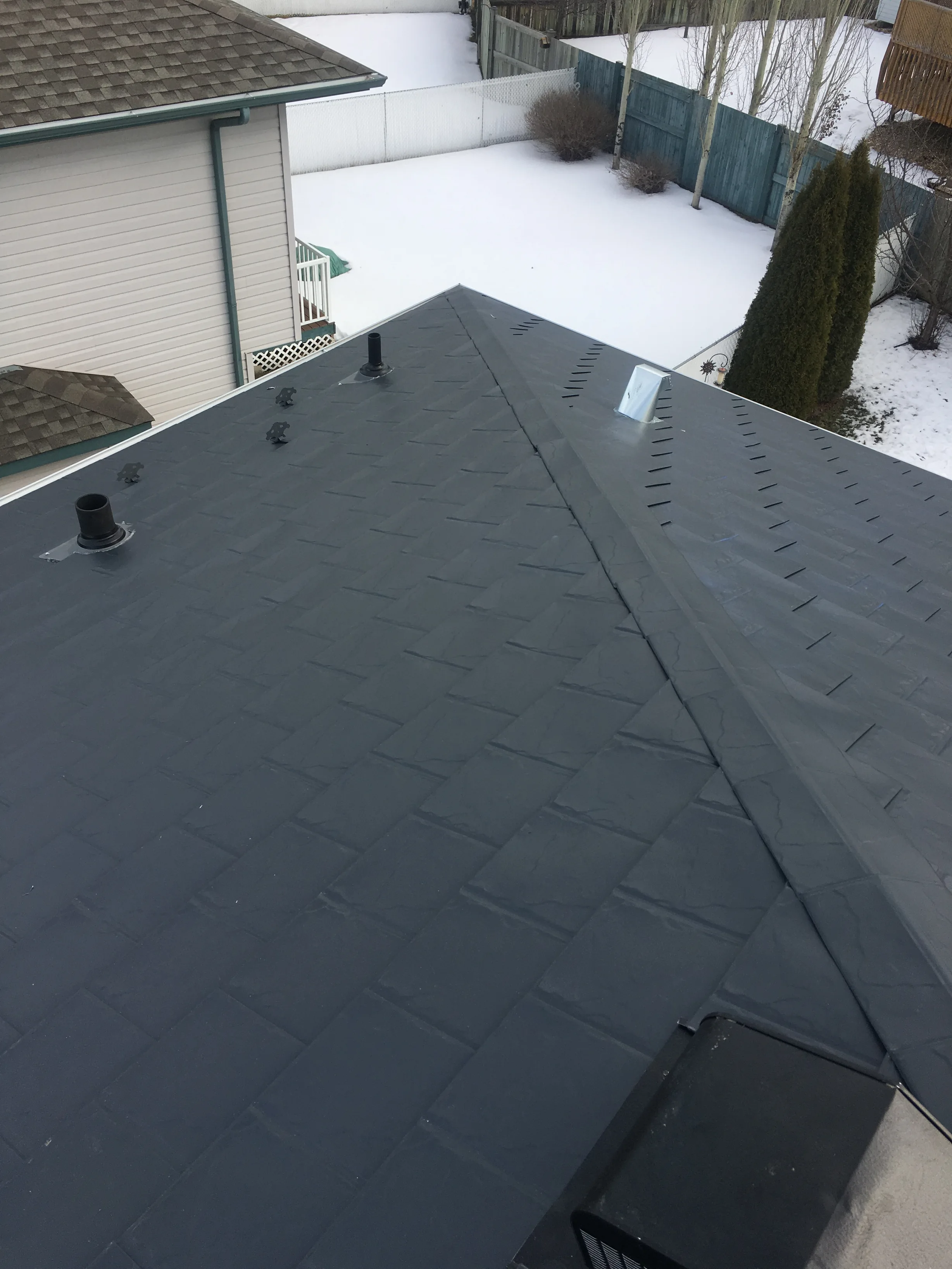 Deep Charcoal Interlock Slate aluminum roof on a single-storey home with a metal roof in a snowy rural, Fort Saskatchewan, Alberta