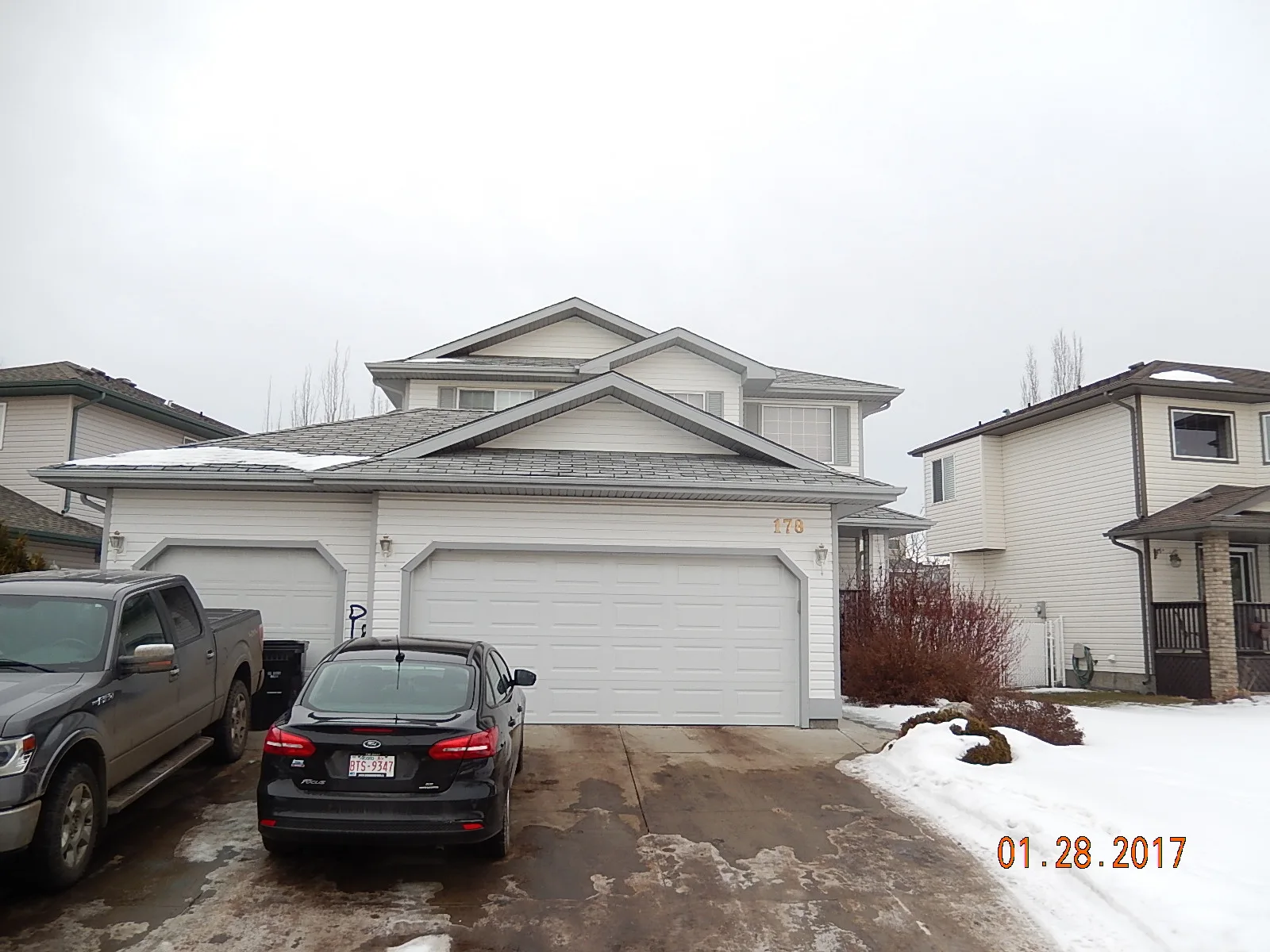 Deep Charcoal Interlock Slate aluminum roof on a white two-storey home with a metal roof in Fort, Fort Saskatchewan, Alberta