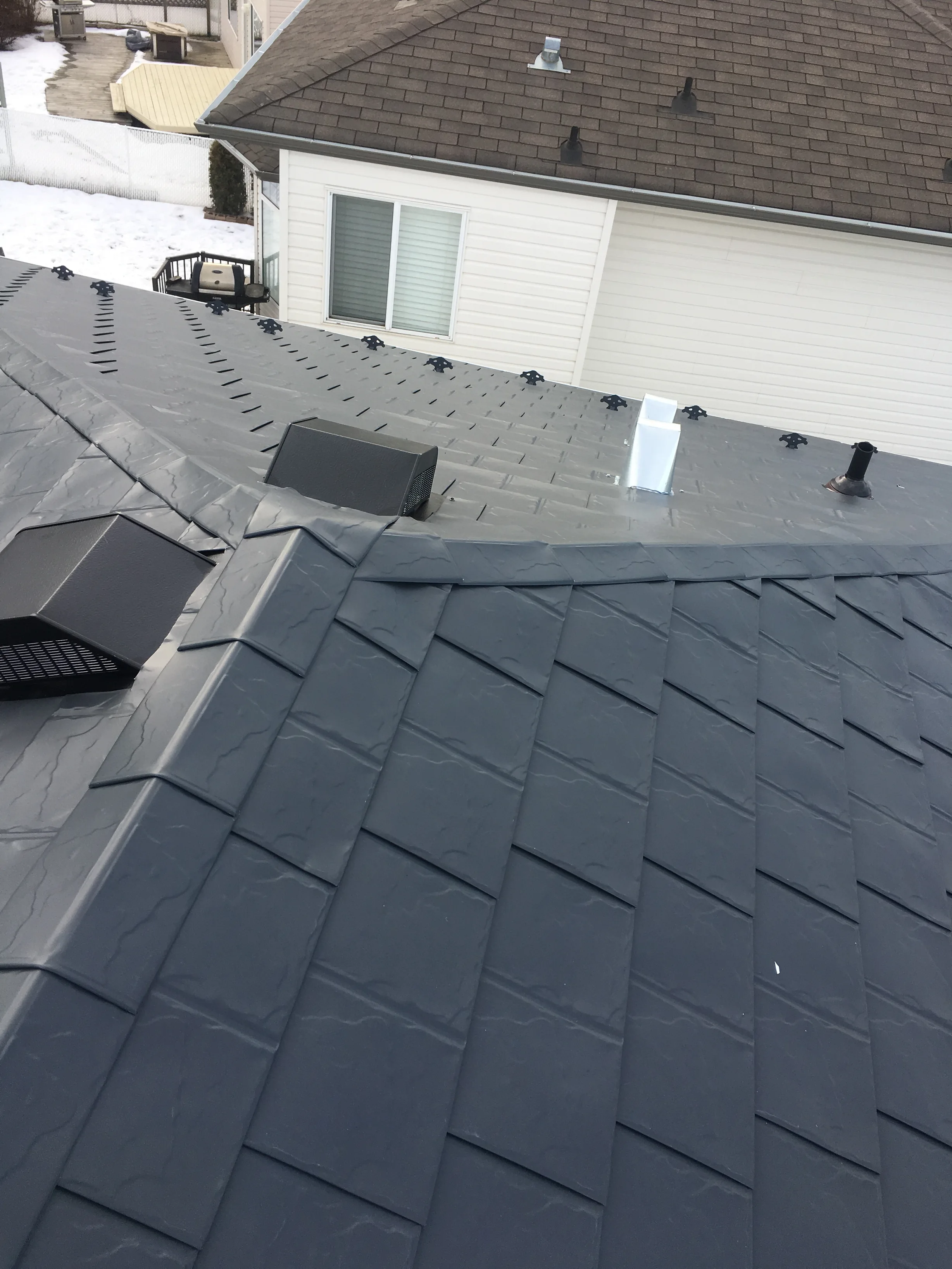 Deep Charcoal Interlock Slate aluminum roof on a two-storey home with a dark roof and white siding in a, Fort Saskatchewan, Alberta