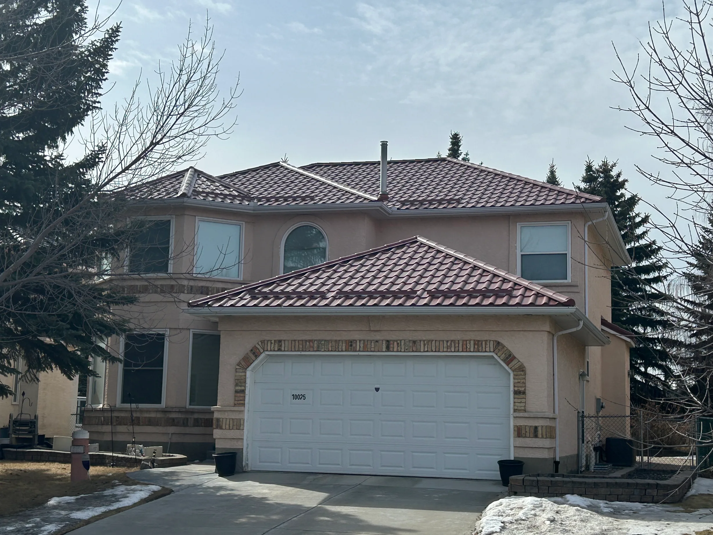 Tile Red Interlock Tile aluminum roof on a tan house with a tile red metal roof in Calgary, Alberta, Calgary, Alberta