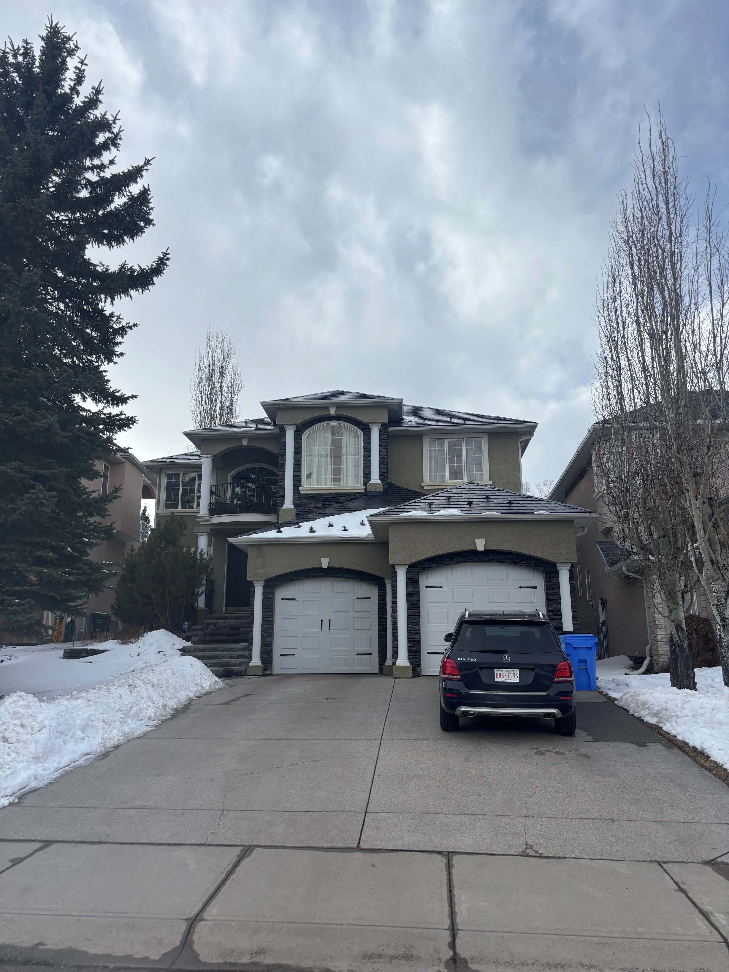 Black Interlock Slate aluminum roof on a brown two-storey home with dormers in a snow-covered, Calgary, Alberta