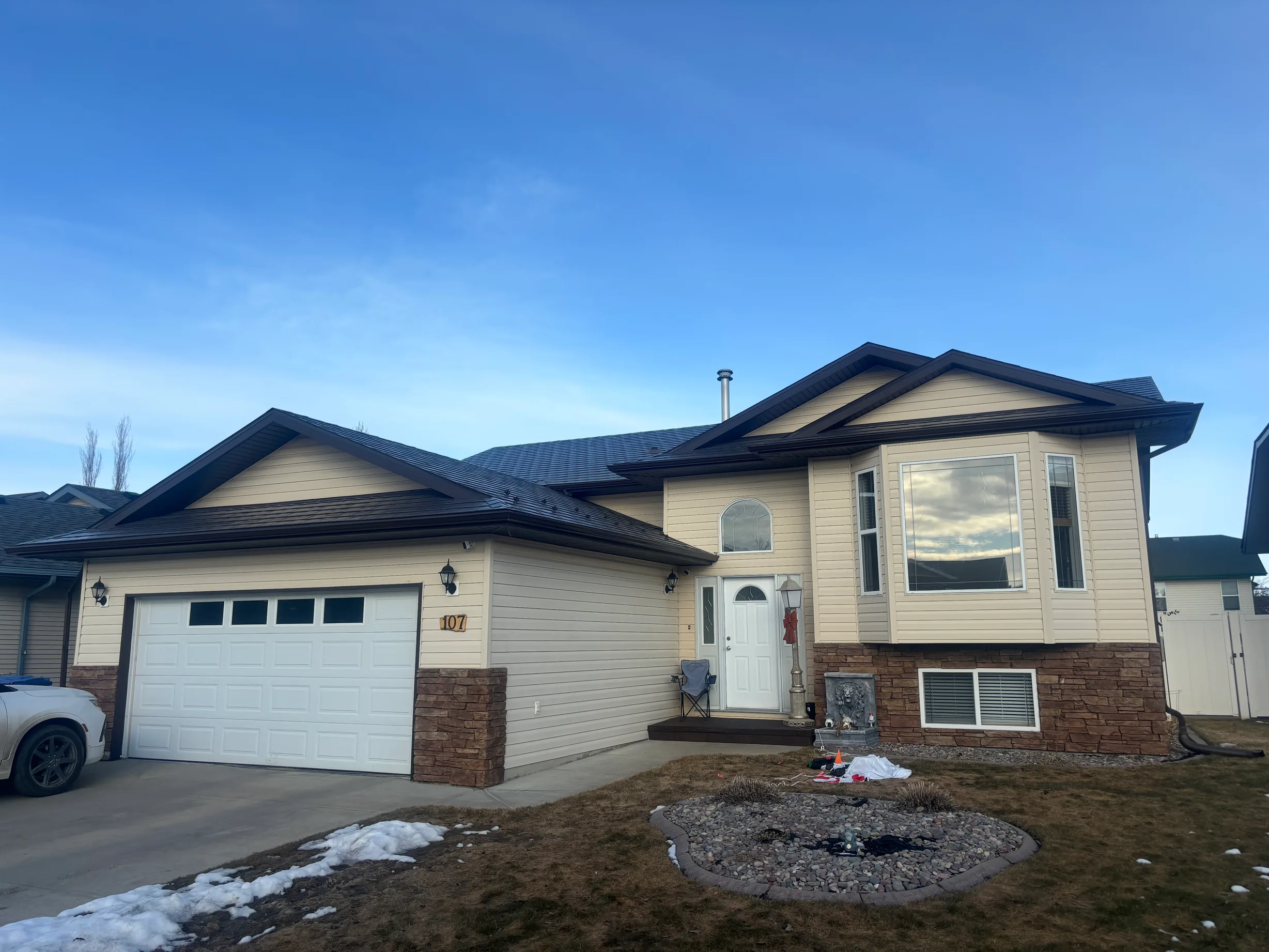 Tudor Brown Interlock Slate aluminum roof on a Tudor brown single-family home in a suburban neighbourhood, Red Deer, Alberta