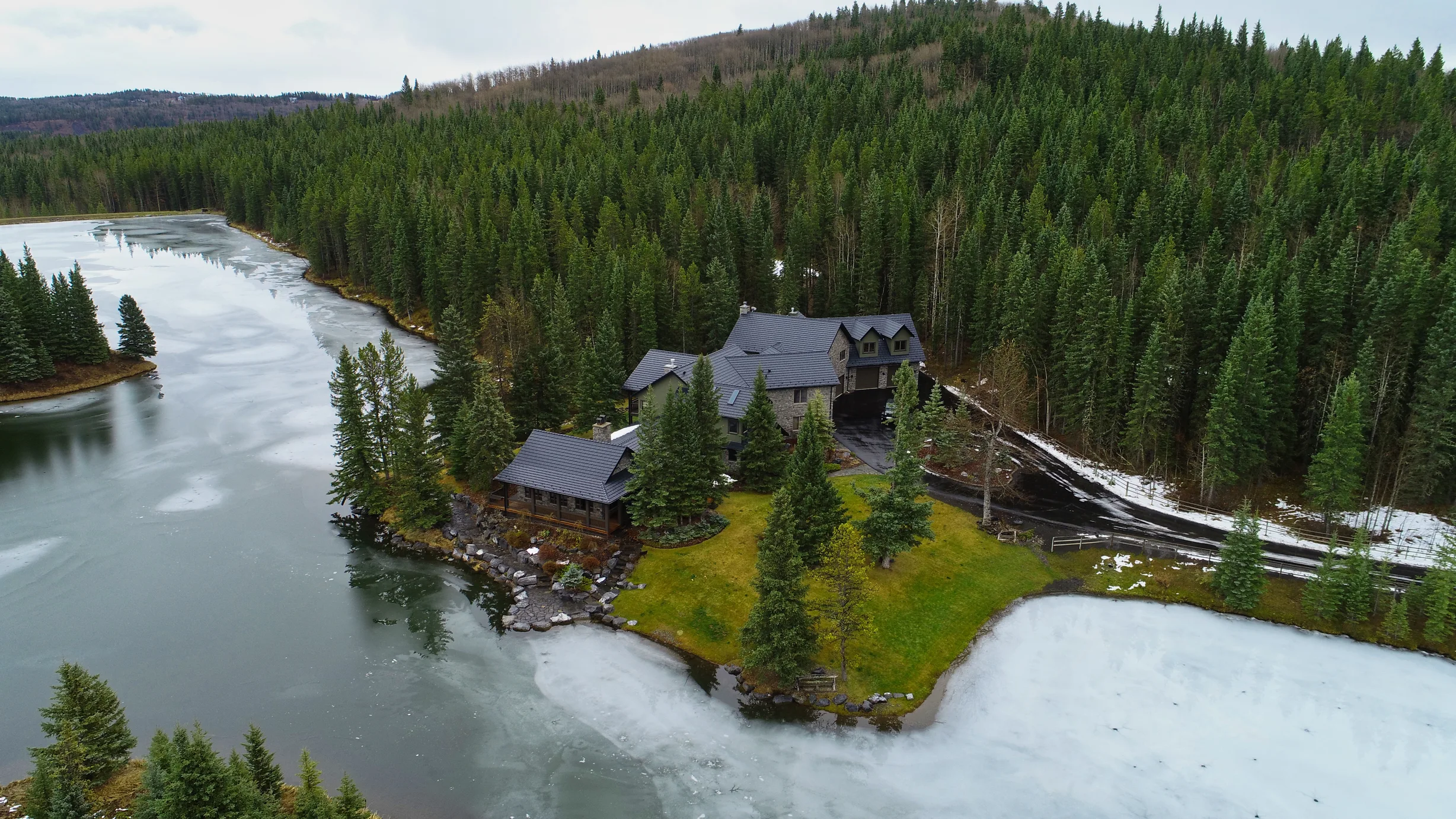 Black Interlock Shake aluminum roof on a large home with a metal roof on a snowy mountain ridge, Bragg Creek, Alberta