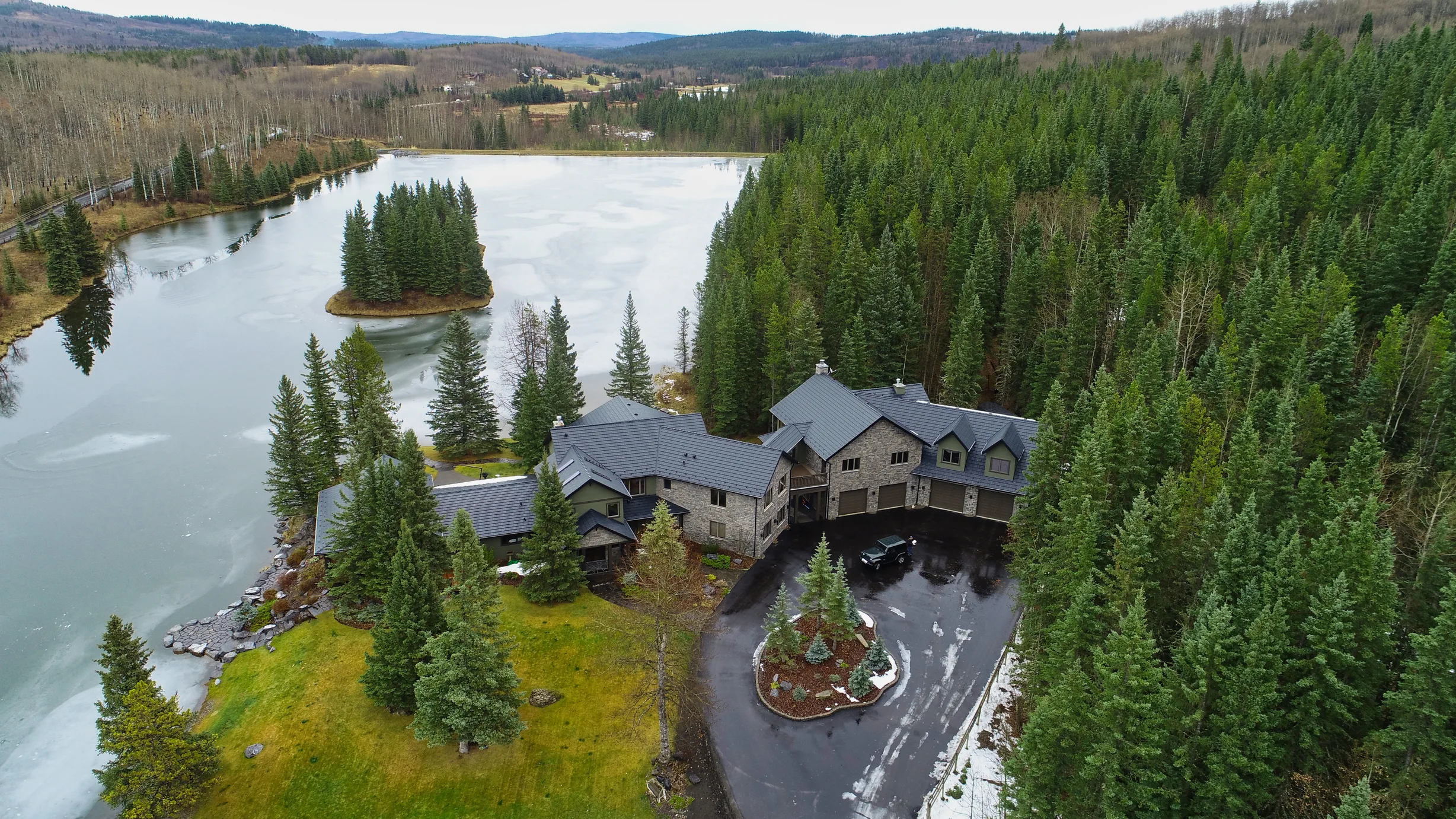 Black Interlock Shake aluminum roof on a house with a black metal roof on a mountain lake shore, Bragg Creek, Alberta