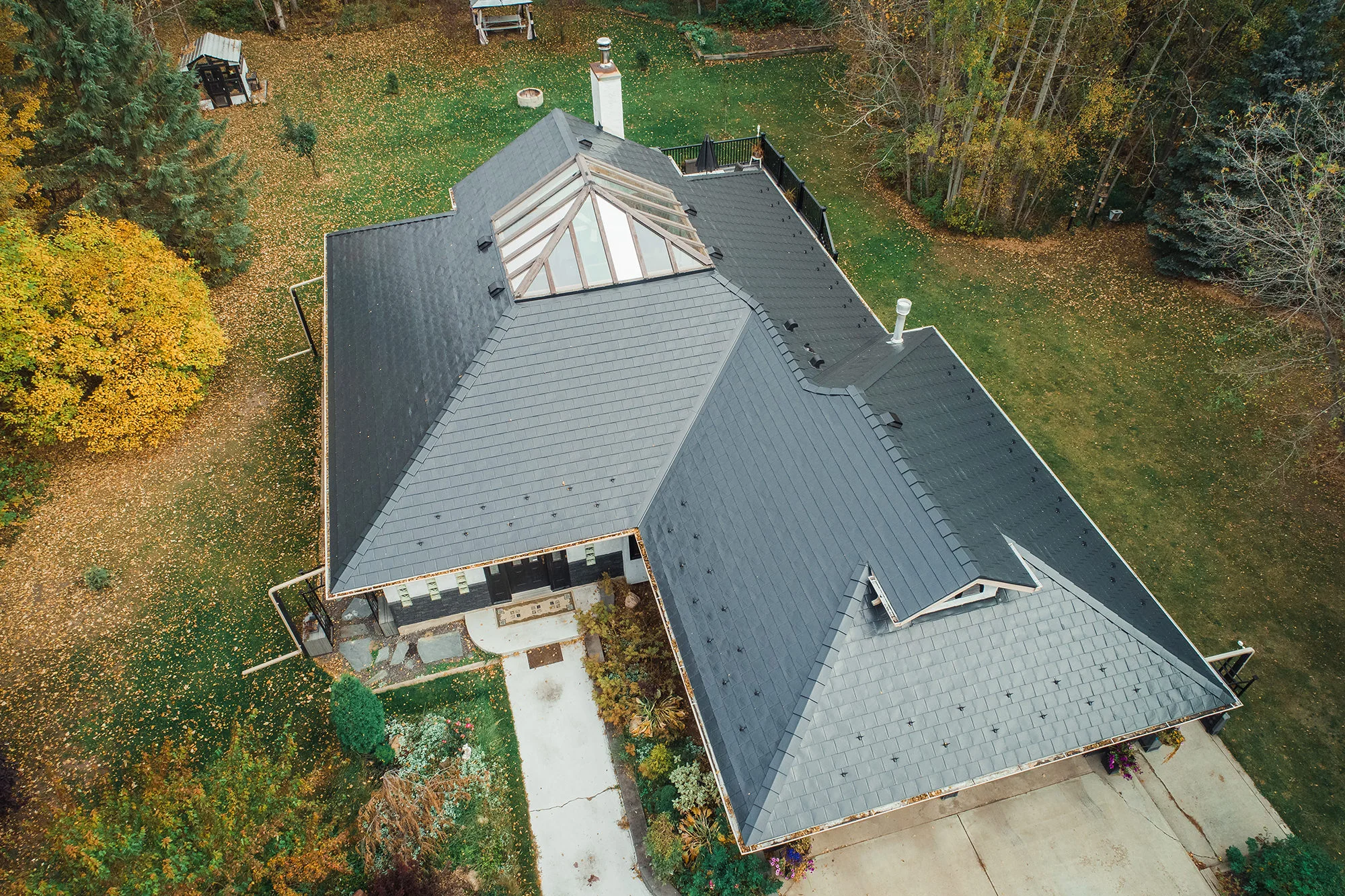 Black Interlock Slate aluminum roof on a black home with a metal roof in a forested rural setting, Spruce Grove, Alberta