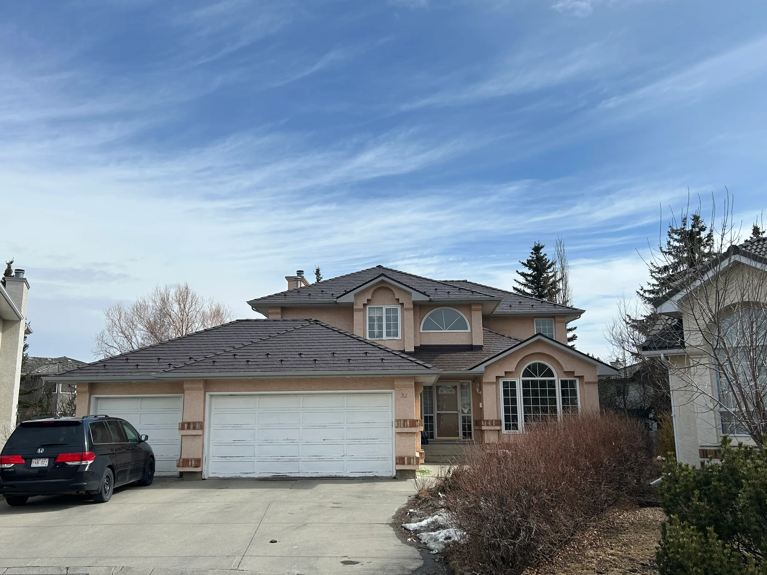 Colonial Brown Interlock Slate aluminum roof on a two-storey home with dormers in a mountainous suburban, Calgary, Alberta