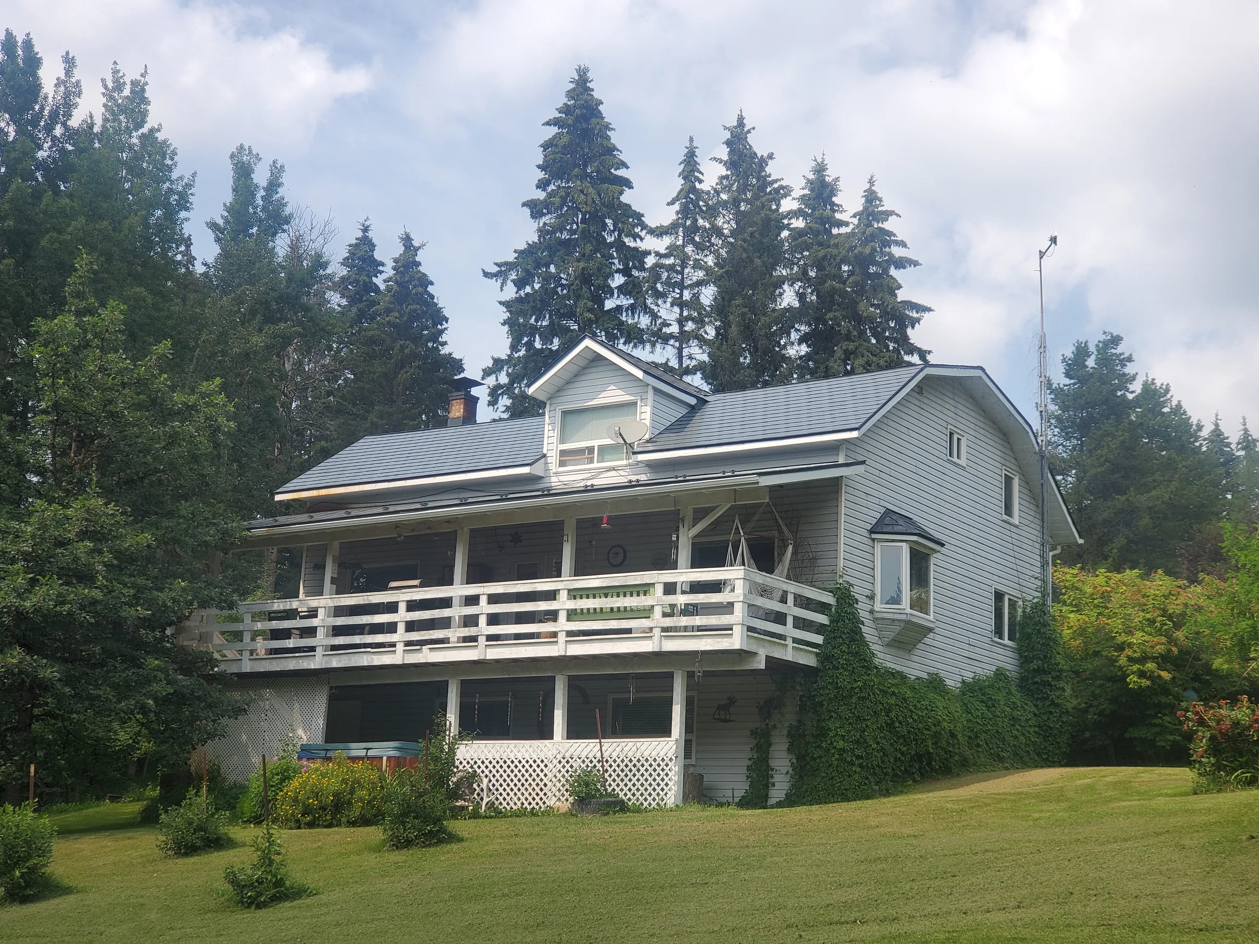 Deep Charcoal Interlock Slate aluminum roof on a two-storey chalet-style home with a metal roof in the, Winfield, Alberta