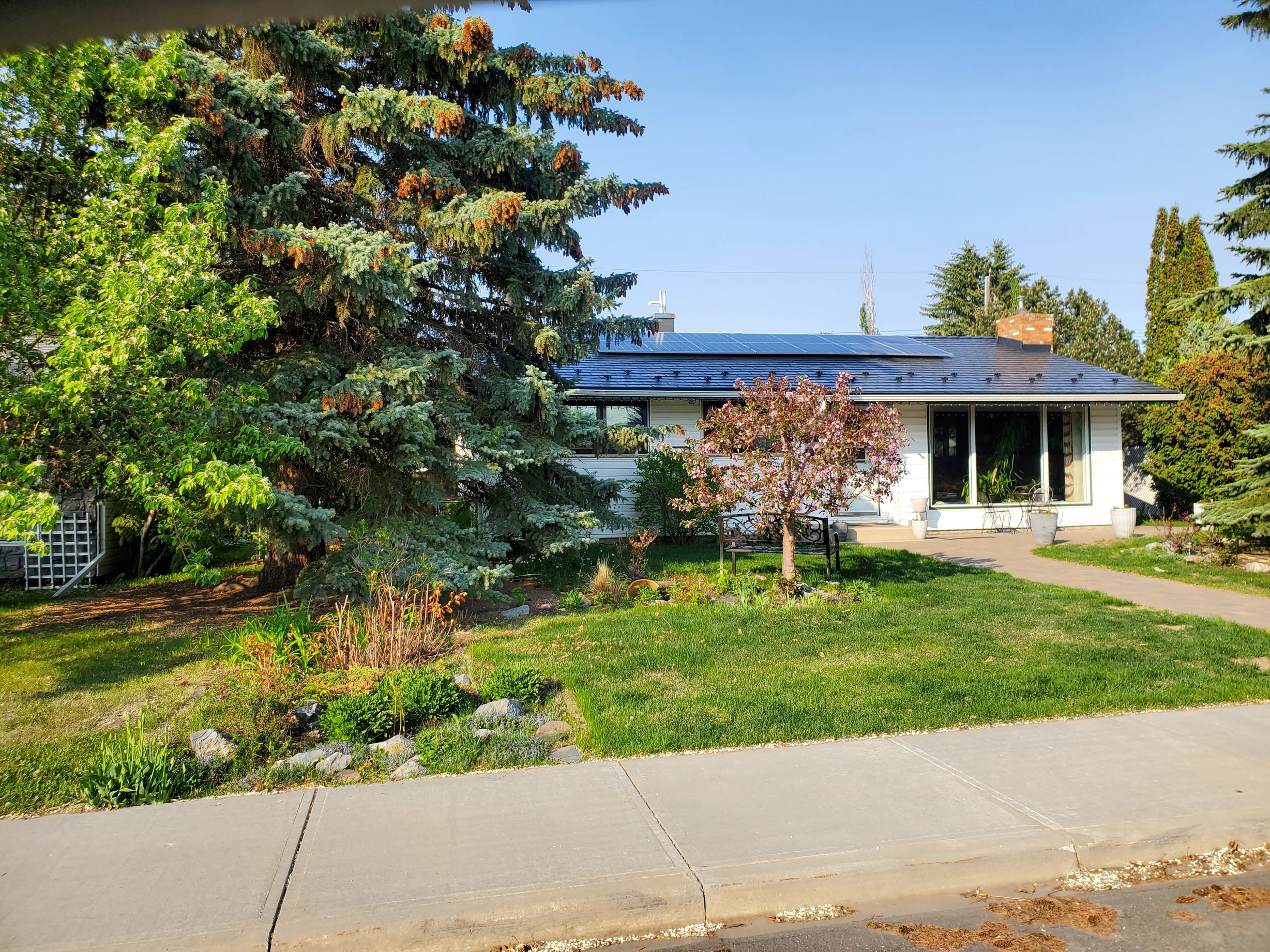 Black Interlock Slate aluminum roof on a white ranch home with a slate metal roof in a suburban, Edmonton, Alberta