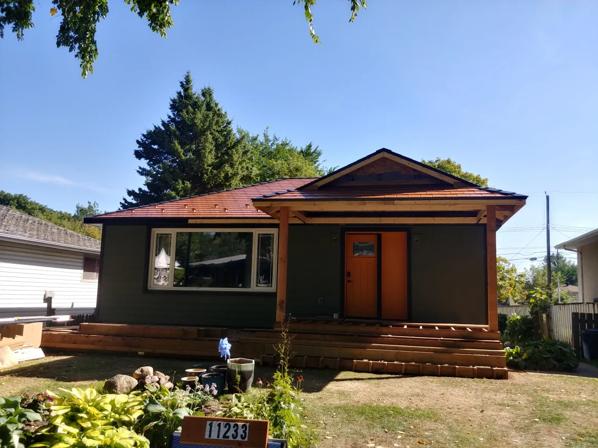 Copper Penny Interlock Slate aluminum roof on a brown home with a metal roof among trees, Edmonton, Alberta