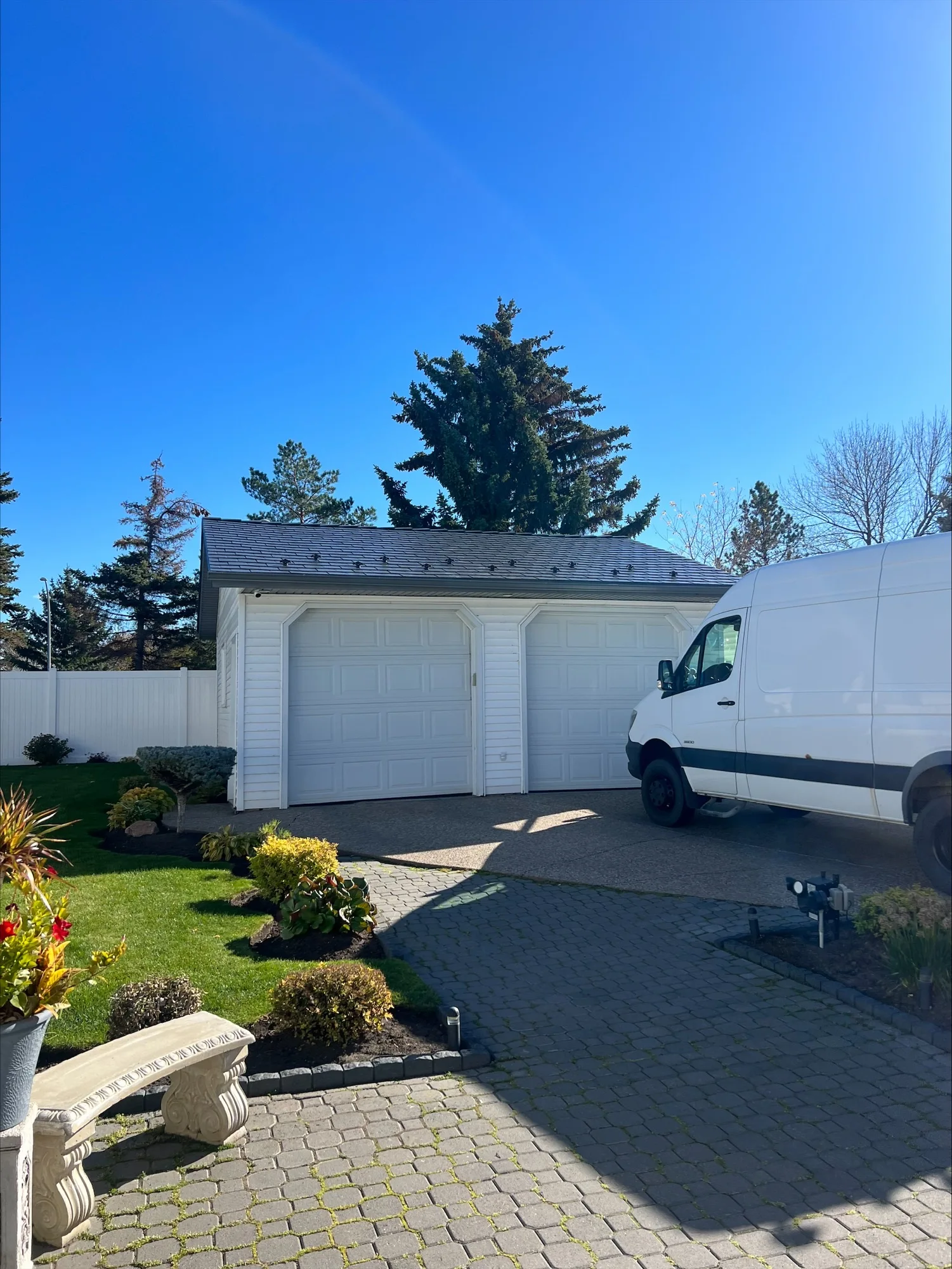 Deep Charcoal Interlock Slate aluminum roof being installed on a white single-family home with a grey roof in a rural, Edmonton, Alberta