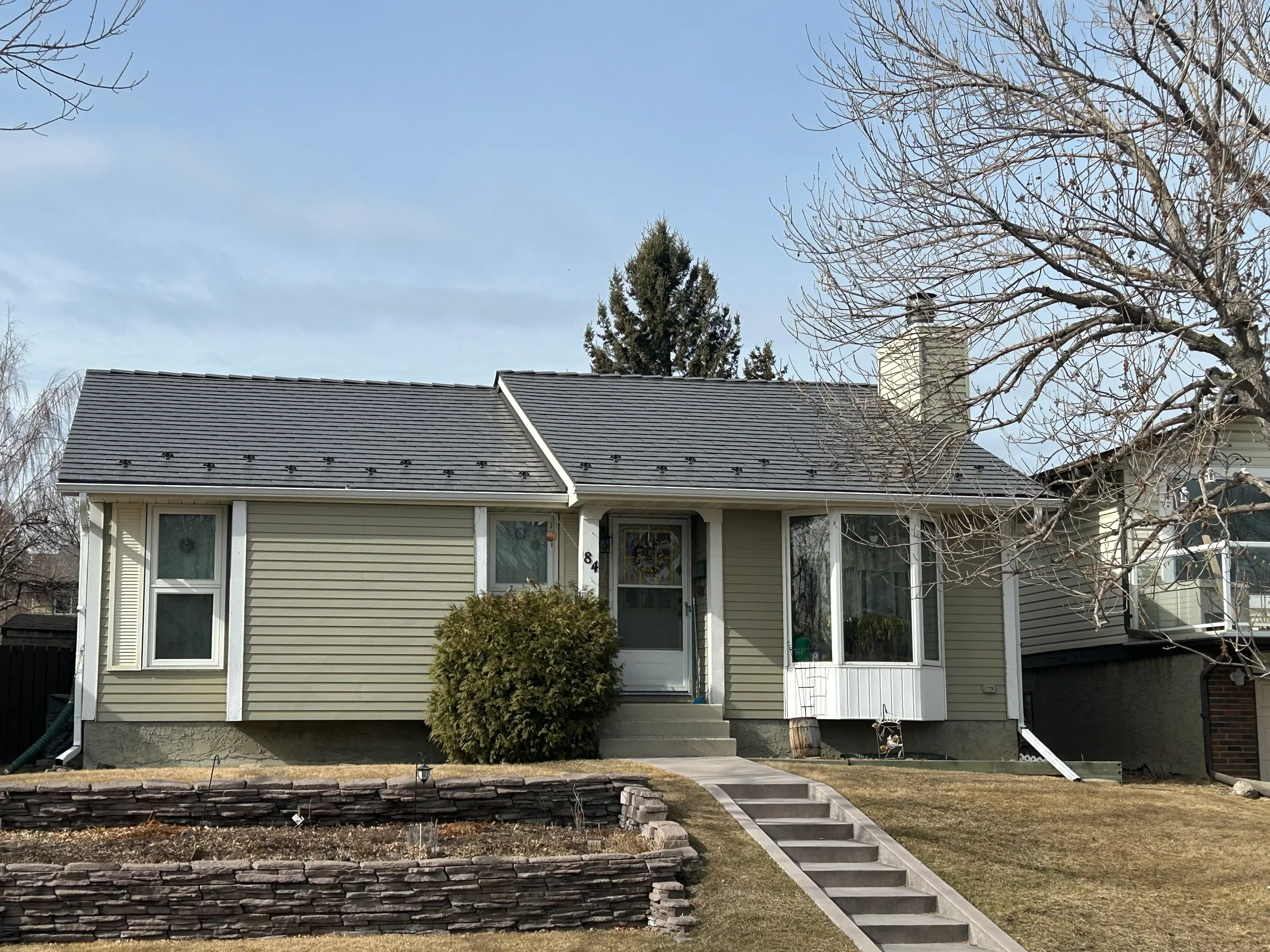 Tile Red Interlock Slate aluminum roof on a green ranch home with dormers in the foothills, Calgary, Alberta