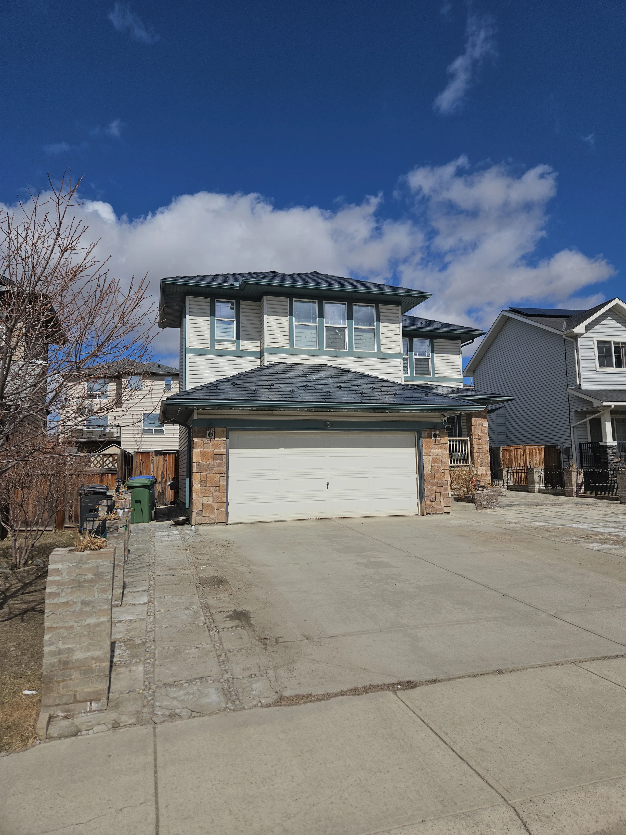 Deep Charcoal Interlock Slate aluminum roof on a two-storey home with stone accents and a metal roof in a, Chestermere, Alberta