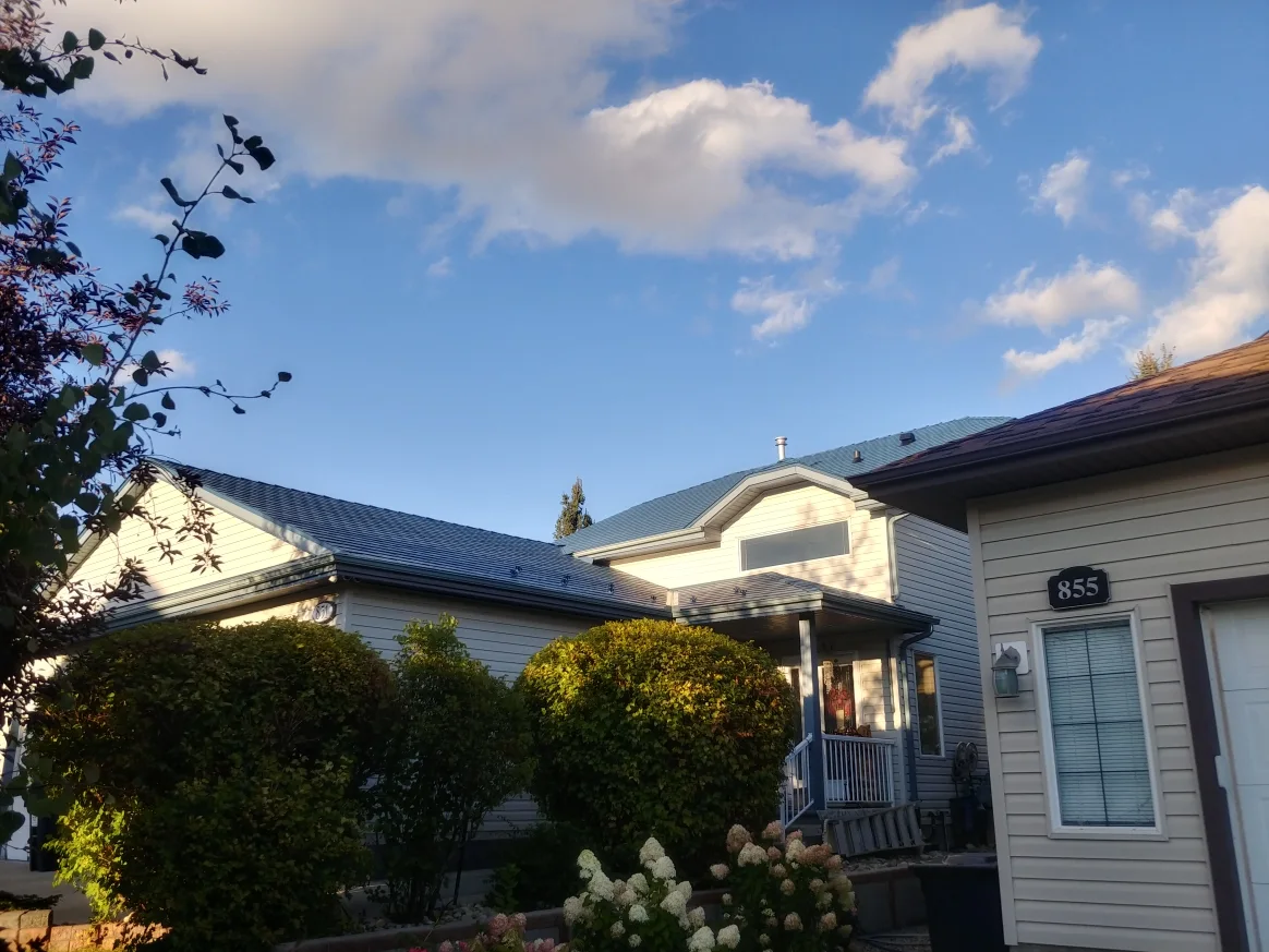 Royal Blue Interlock Slate aluminum roof on a beige bungalow with a metal roof in a rural, suburban, Devon, Alberta