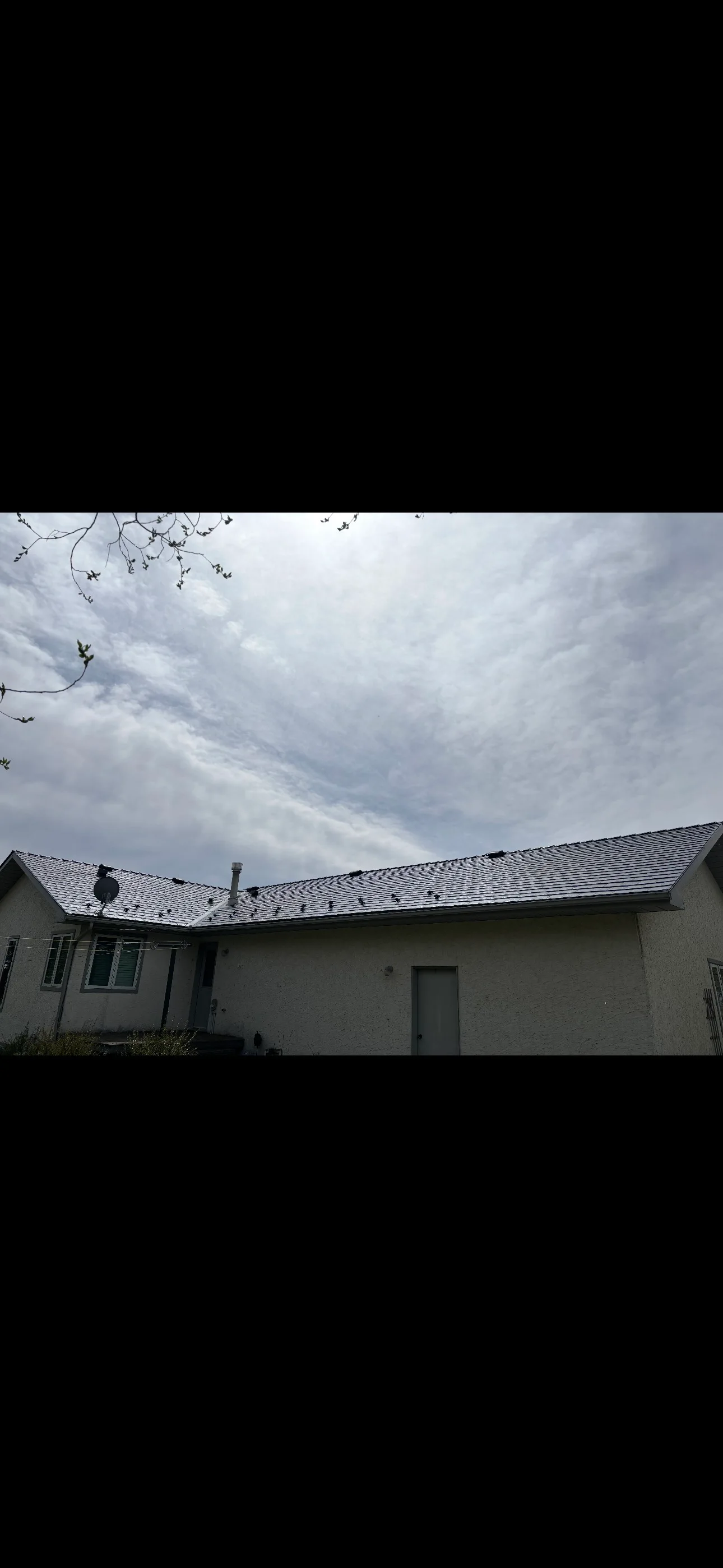 Deep Charcoal Interlock Slate aluminum roof on a beige one-storey home with dormers in a rural setting, Red Deer County, Alberta