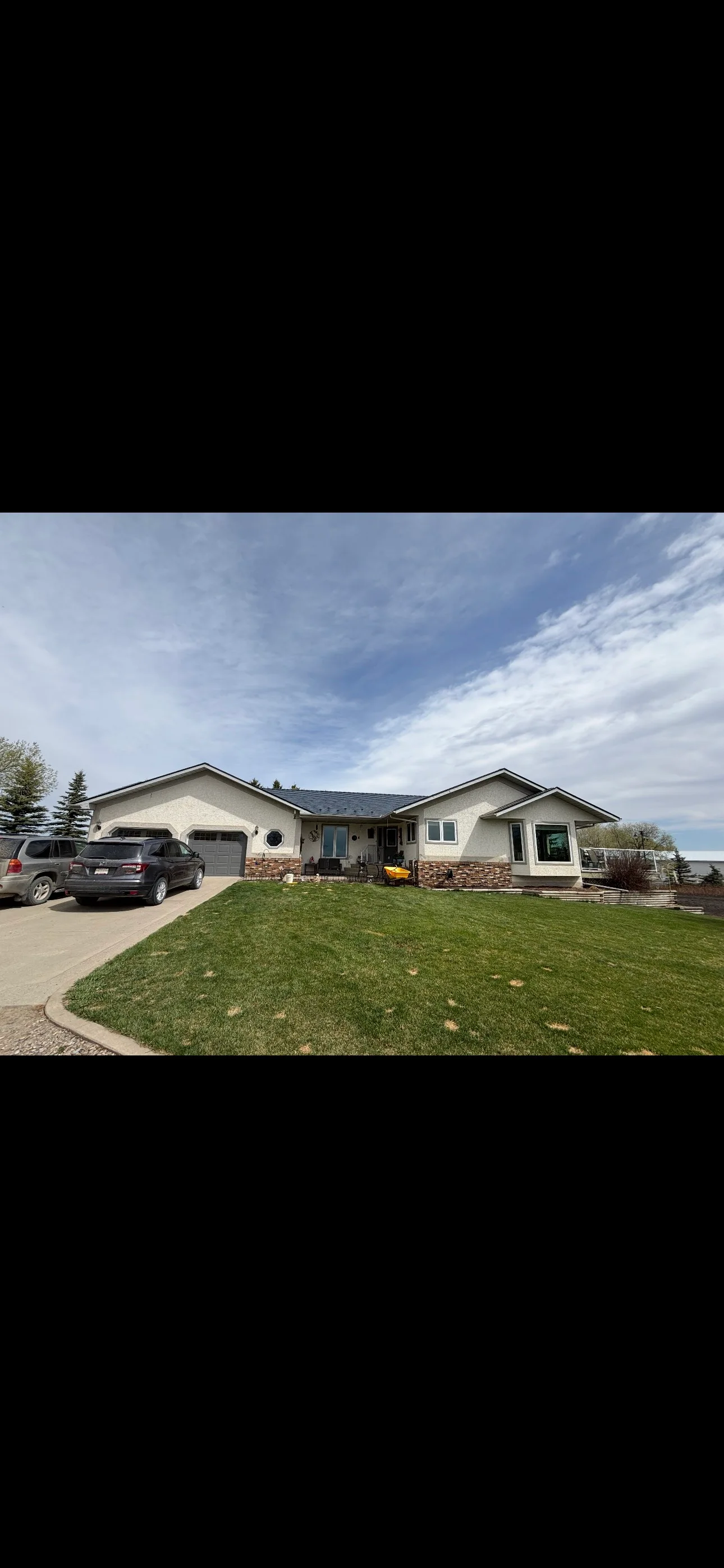 Deep Charcoal Interlock Slate aluminum roof on a white ranch-style home with a metal roof in a rural, Red Deer County, Alberta