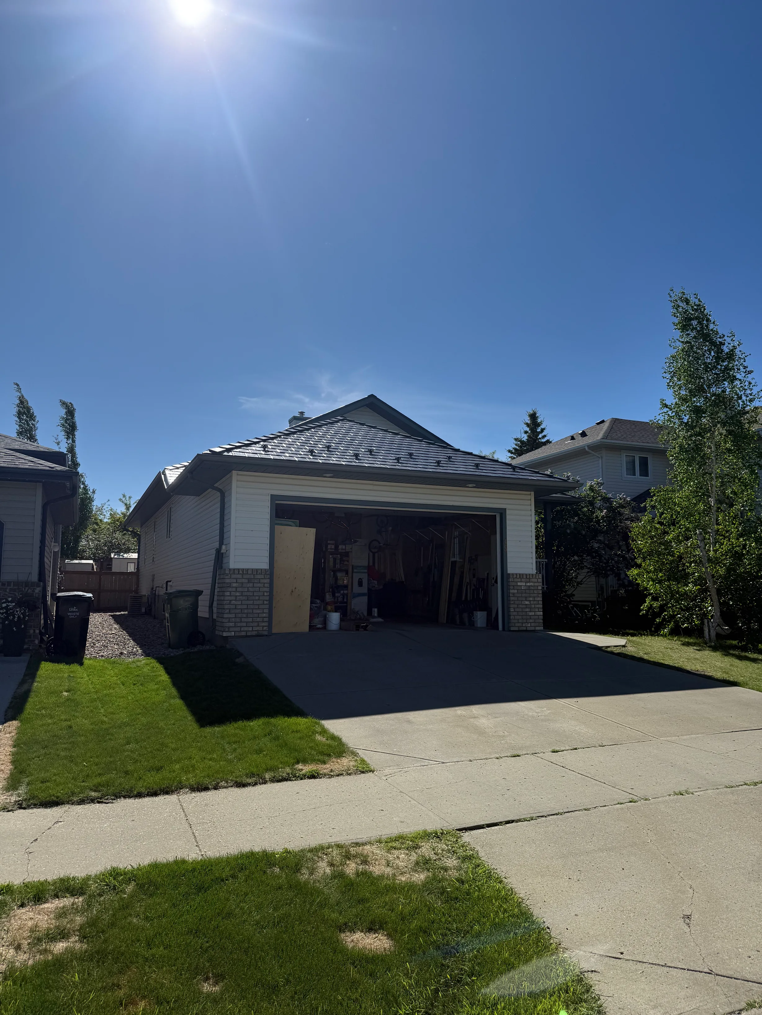 Deep Charcoal Interlock Slate aluminum roof on a white single-family home with a metal roof in a suburban, Leduc, Alberta