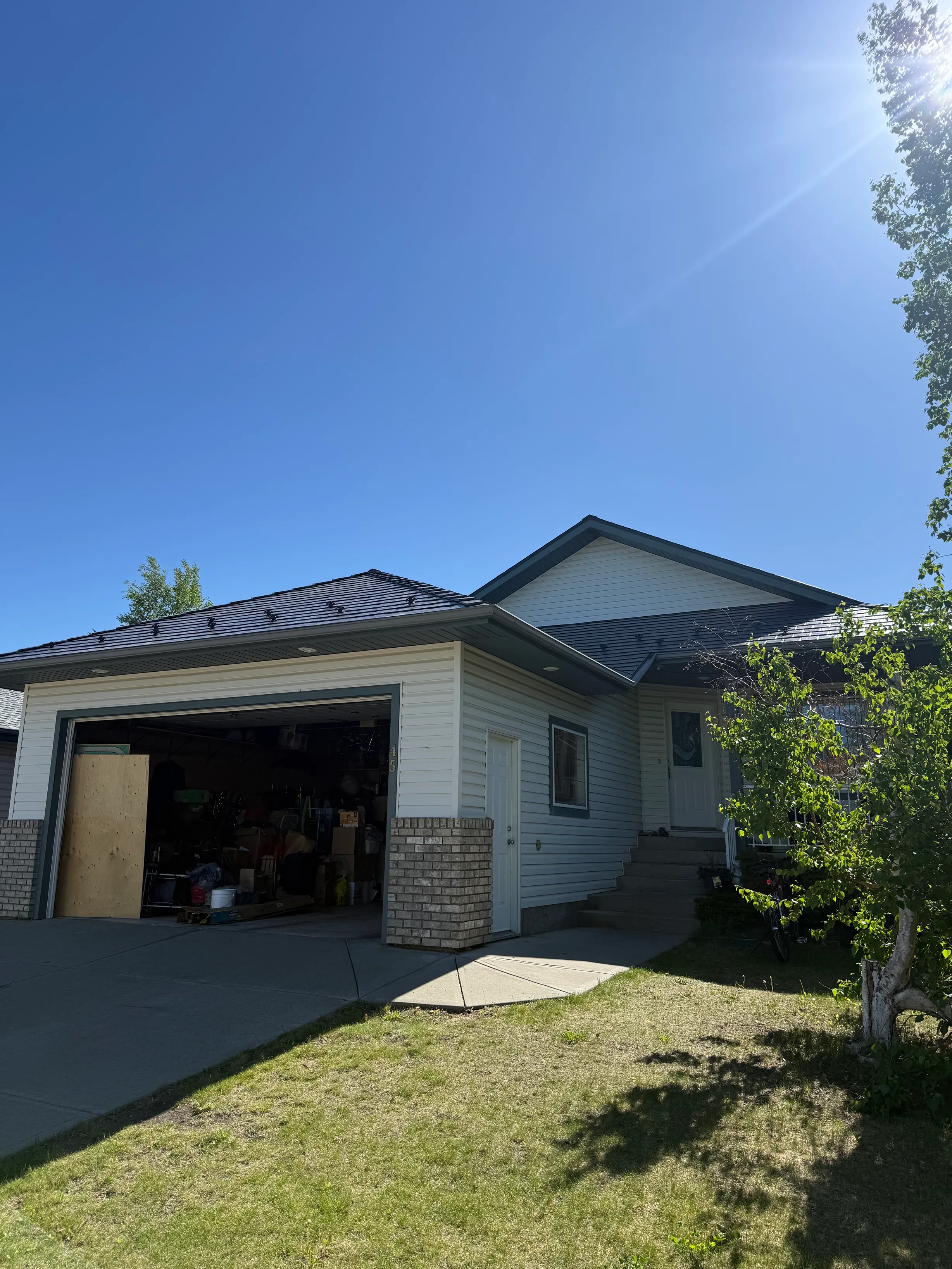 Deep Charcoal Interlock Slate aluminum roof on a single-storey home with a garage and white siding among, Leduc, Alberta