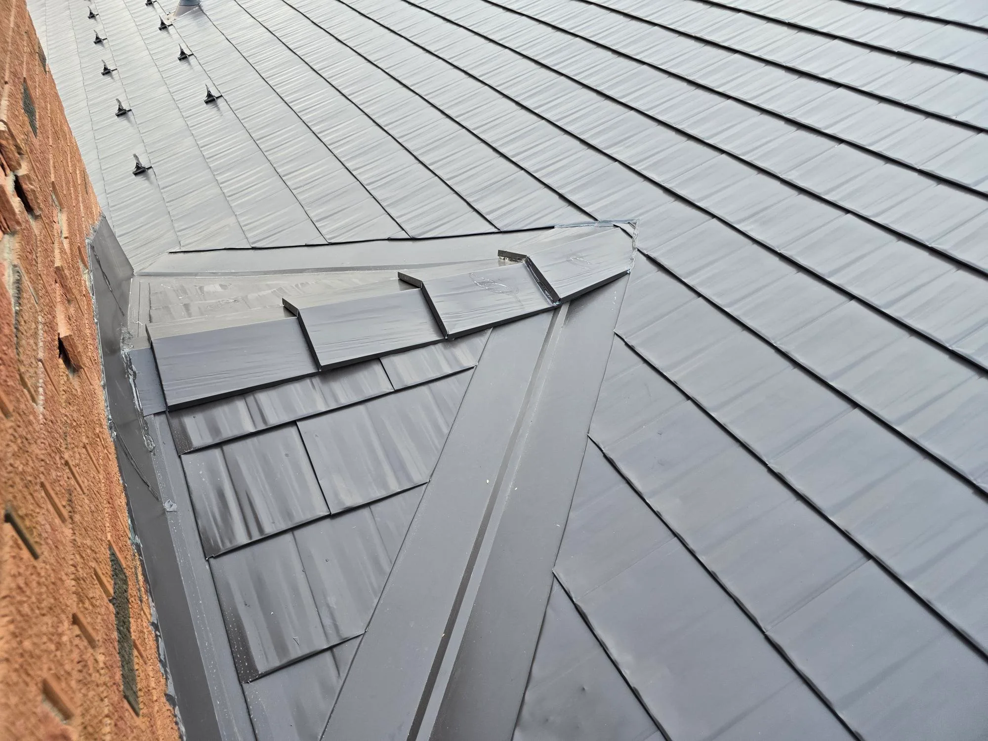 Tudor Brown Interlock Cedar Shingle aluminum roof on a brown two-storey Tudor home with dormers in the mountains, Rocky Mountain House, Alberta