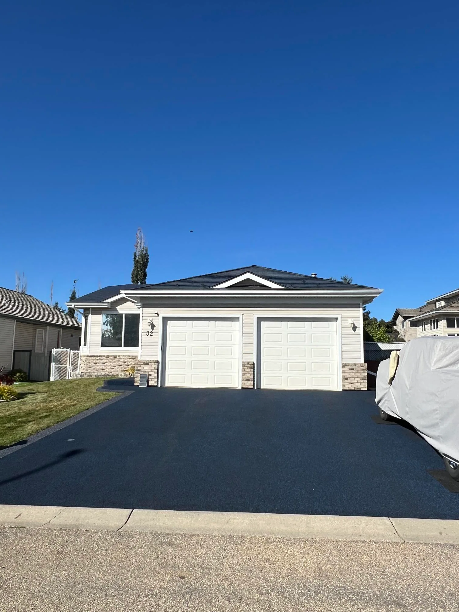 Deep Charcoal Interlock Cedar Shingle aluminum roof on a Deep Charcoal metal roof on a white home with a stone, Stony Plain, Alberta