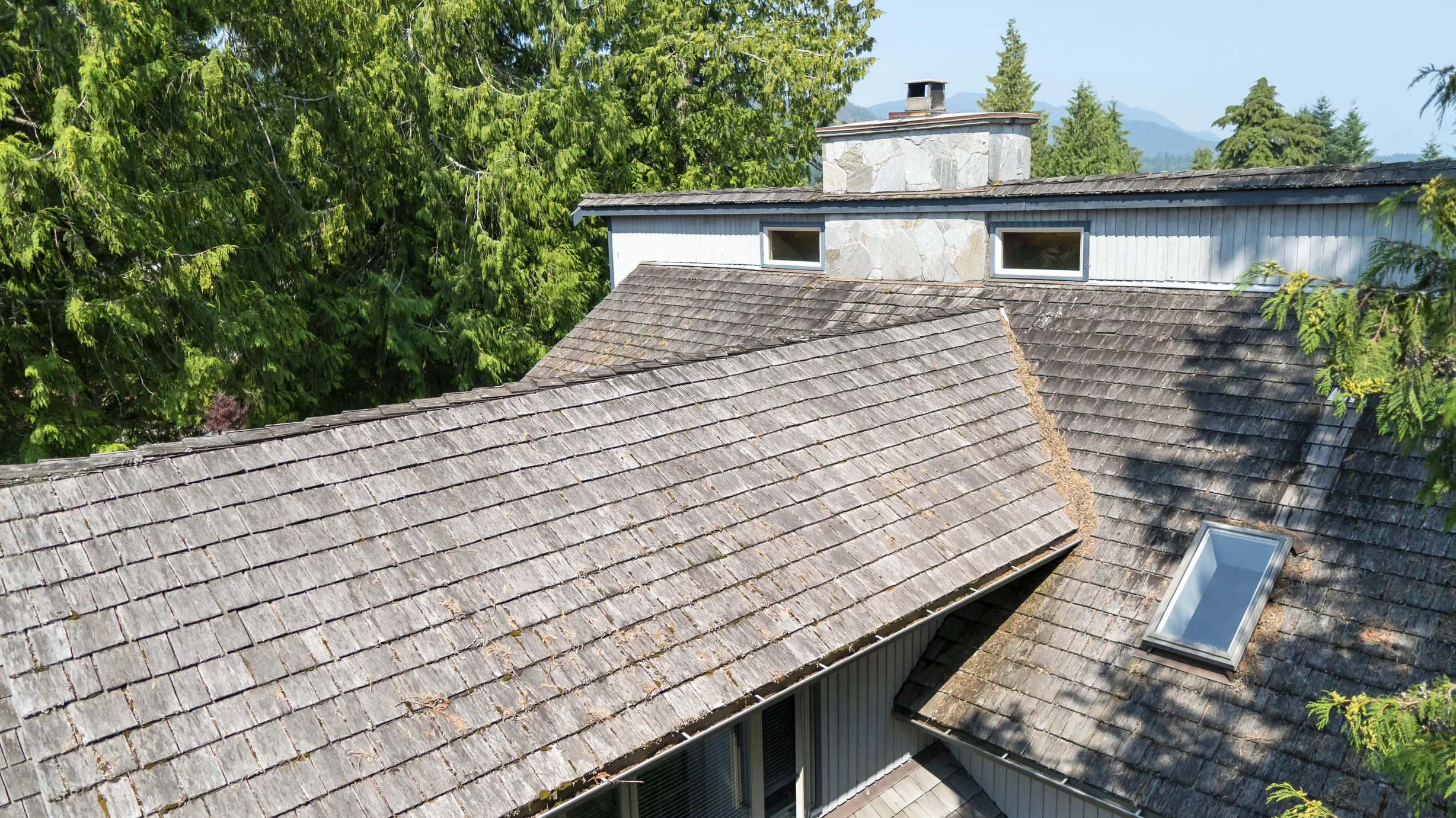 Before: a mossy wood shake roof on the home, Sechelt, British Columbia, ahead of a Deep Charcoal Interlock Slate aluminum roof