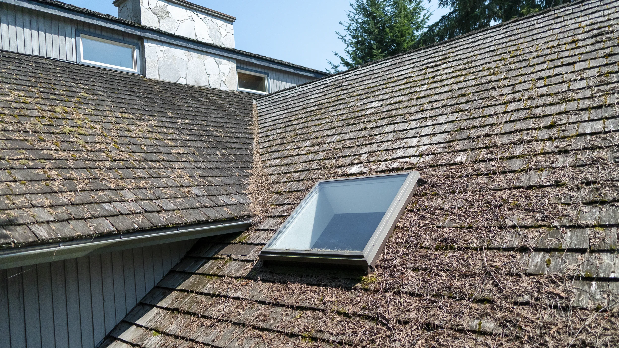 Before: a mossy wood shake roof on the home, Sechelt, British Columbia, ahead of a Deep Charcoal Interlock Slate aluminum roof