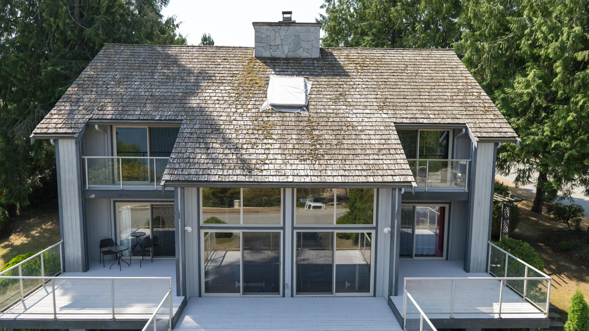 Before: a mossy wood shake roof on the home, Sechelt, British Columbia, ahead of a Deep Charcoal Interlock Slate aluminum roof