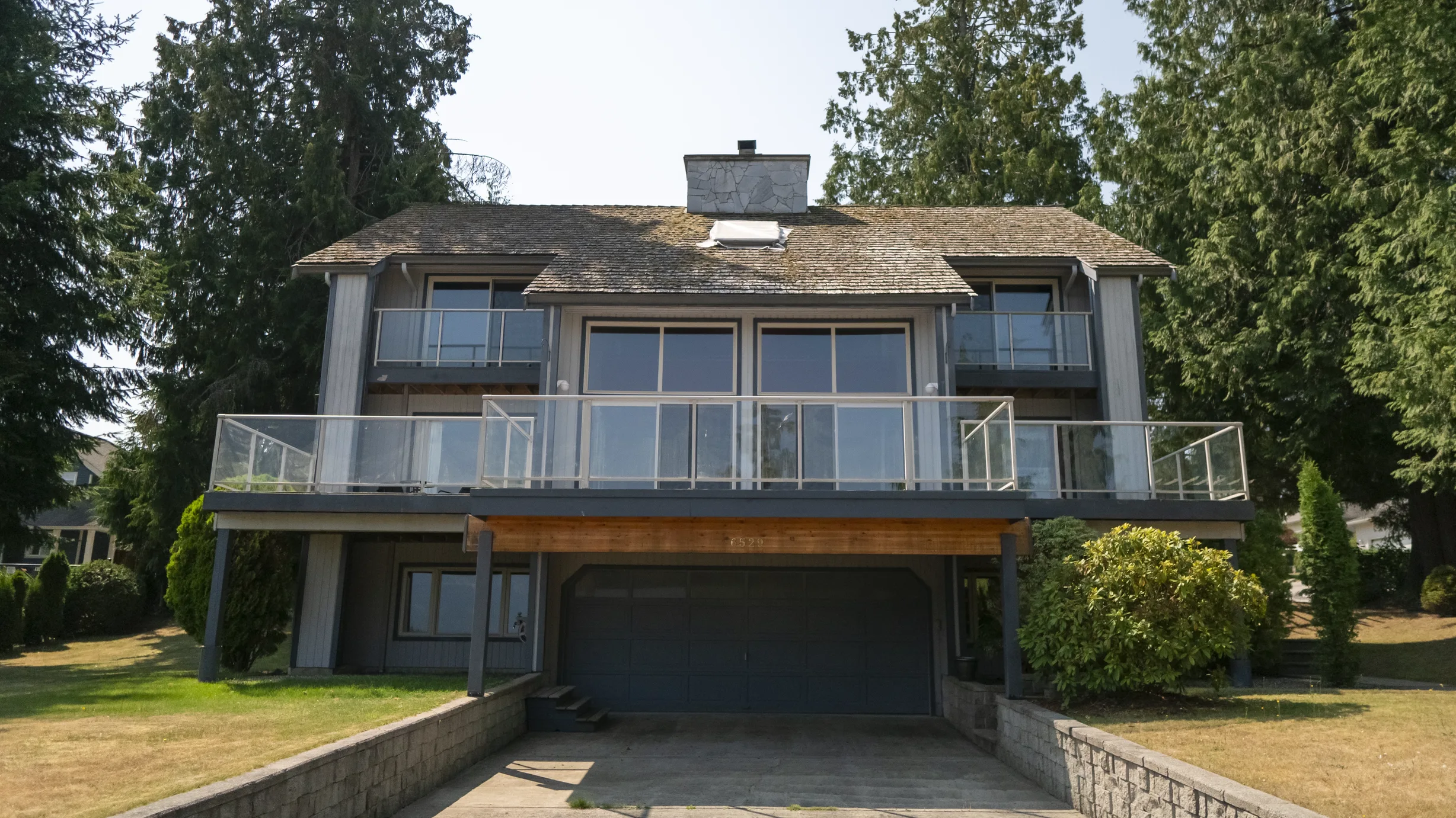 Before: a mossy wood shake roof on the home, Sechelt, British Columbia, ahead of a Deep Charcoal Interlock Slate aluminum roof