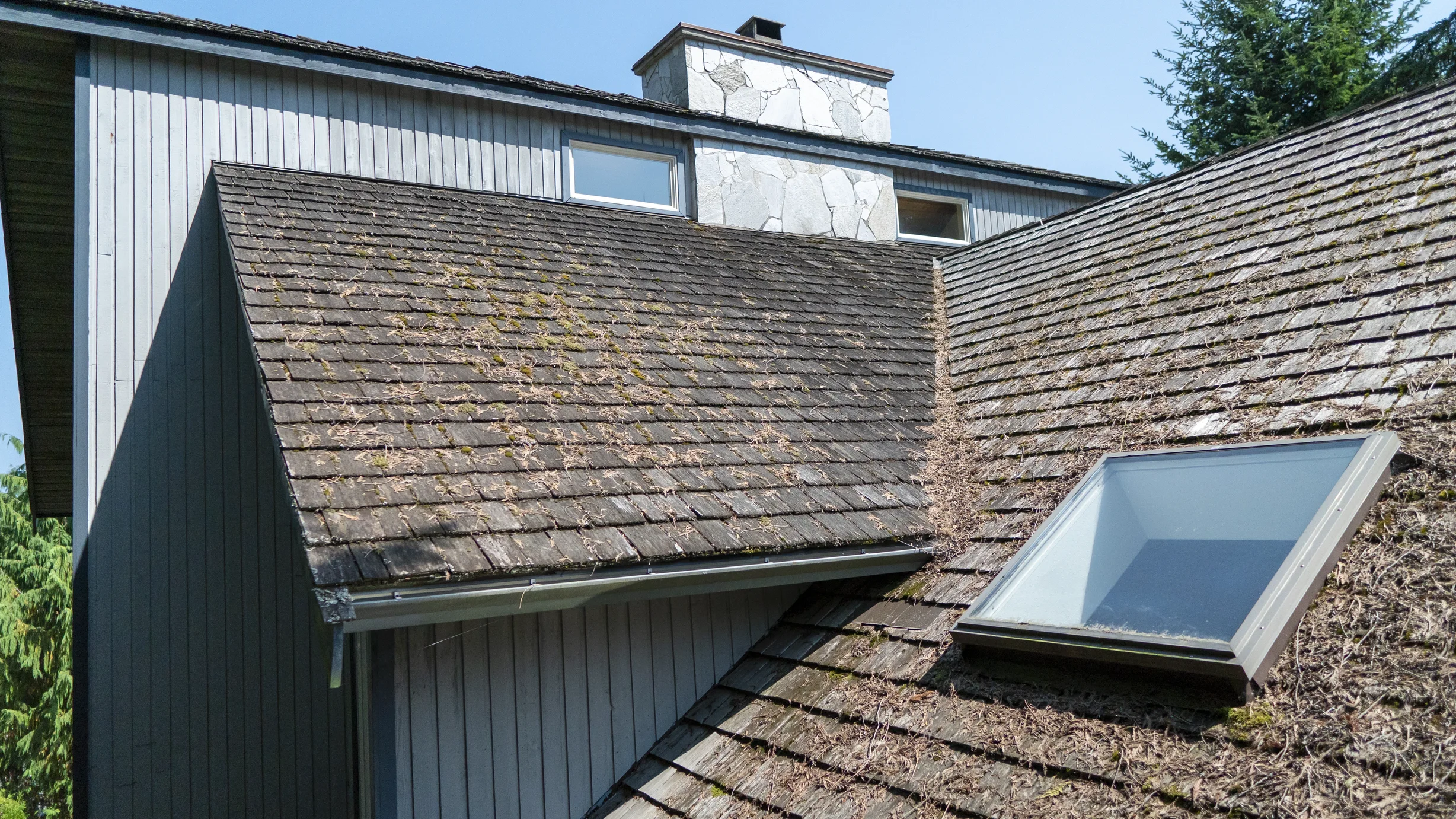 Before: a mossy wood shake roof on the home, Sechelt, British Columbia, ahead of a Deep Charcoal Interlock Slate aluminum roof