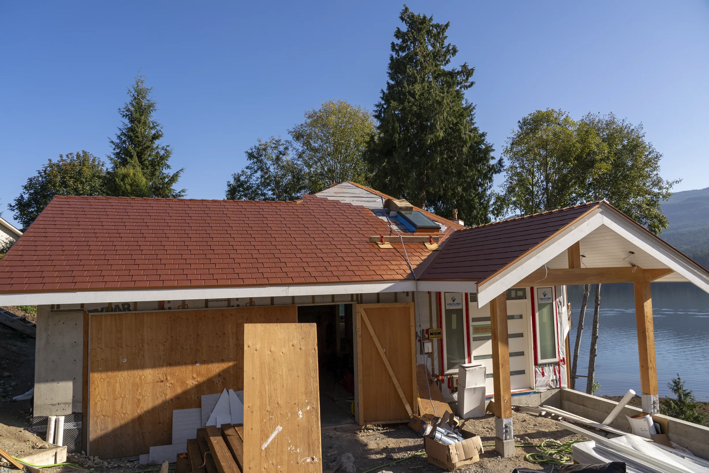 Copper Penny Interlock Slate aluminum roof being installed on a two-storey home with copper penny metal roof on waterfront, Sechelt, British Columbia