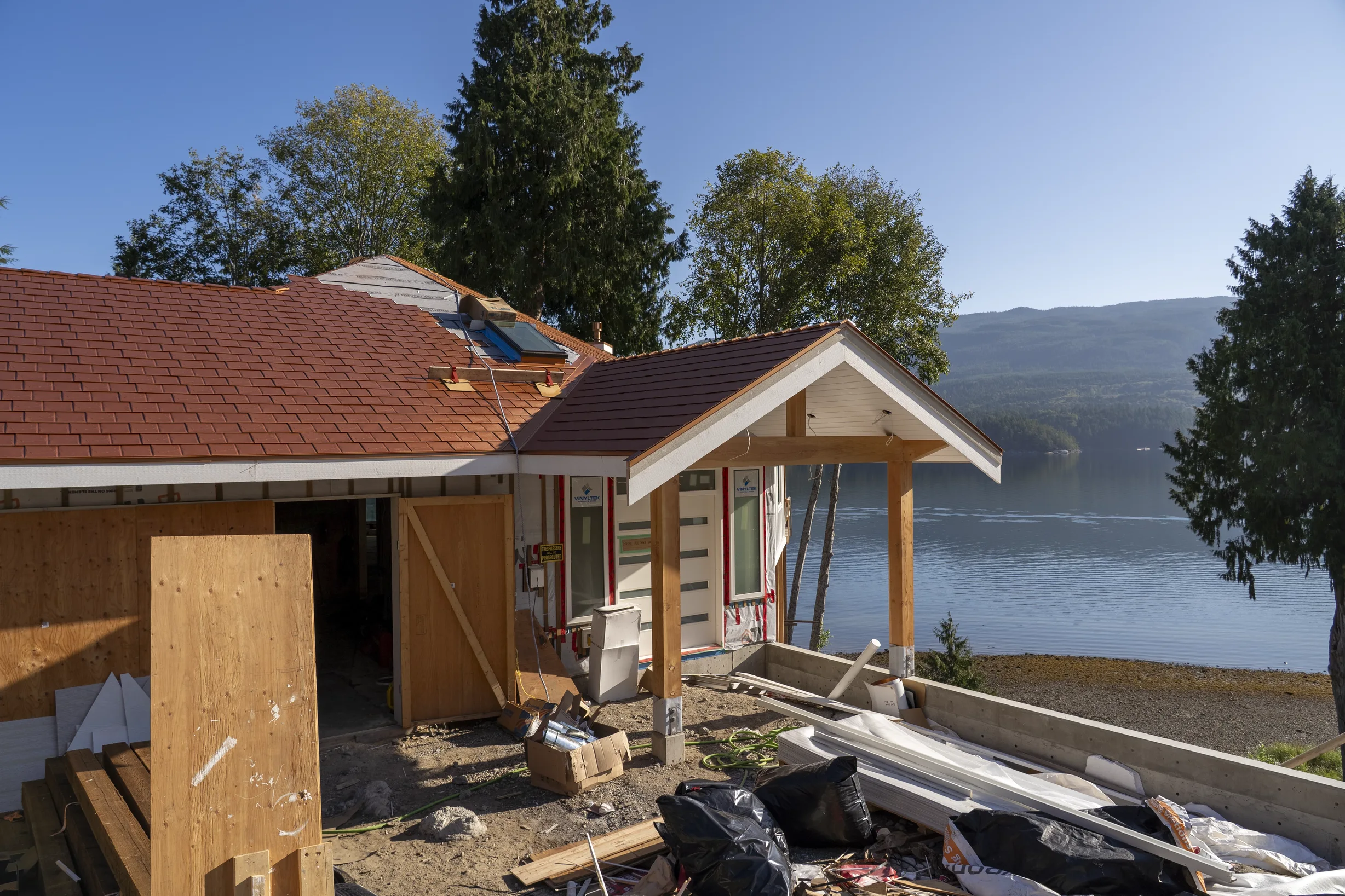 Copper Penny Interlock Slate aluminum roof being installed on a house with a metal roof on the waterfront, replacing new construction, Sechelt, British Columbia